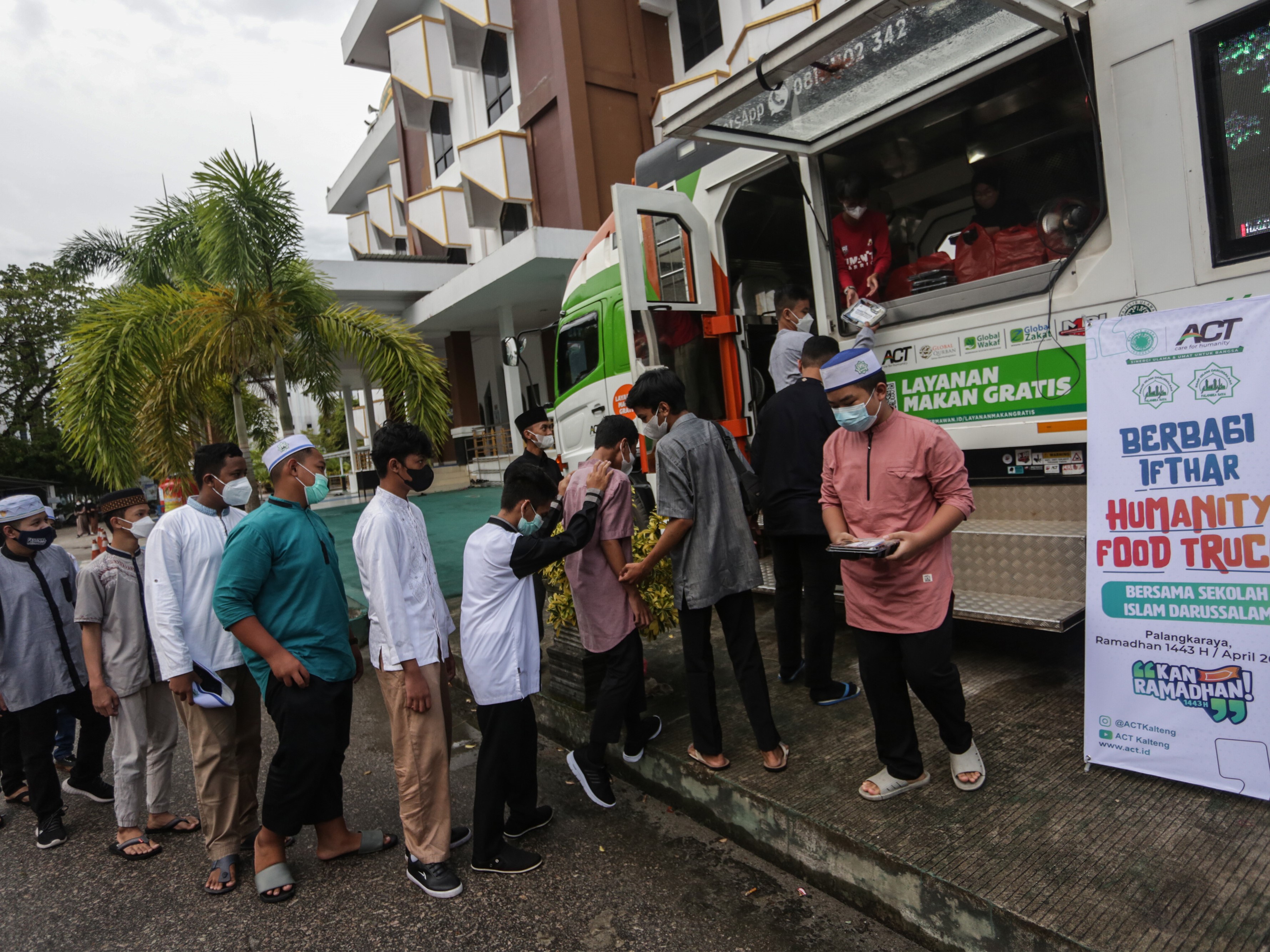 Relawan membagikan makanan gratis kepada warga di halaman Masjid Darussalam, Palangkaraya, Kalimantan Tengah, Senin (11/4).