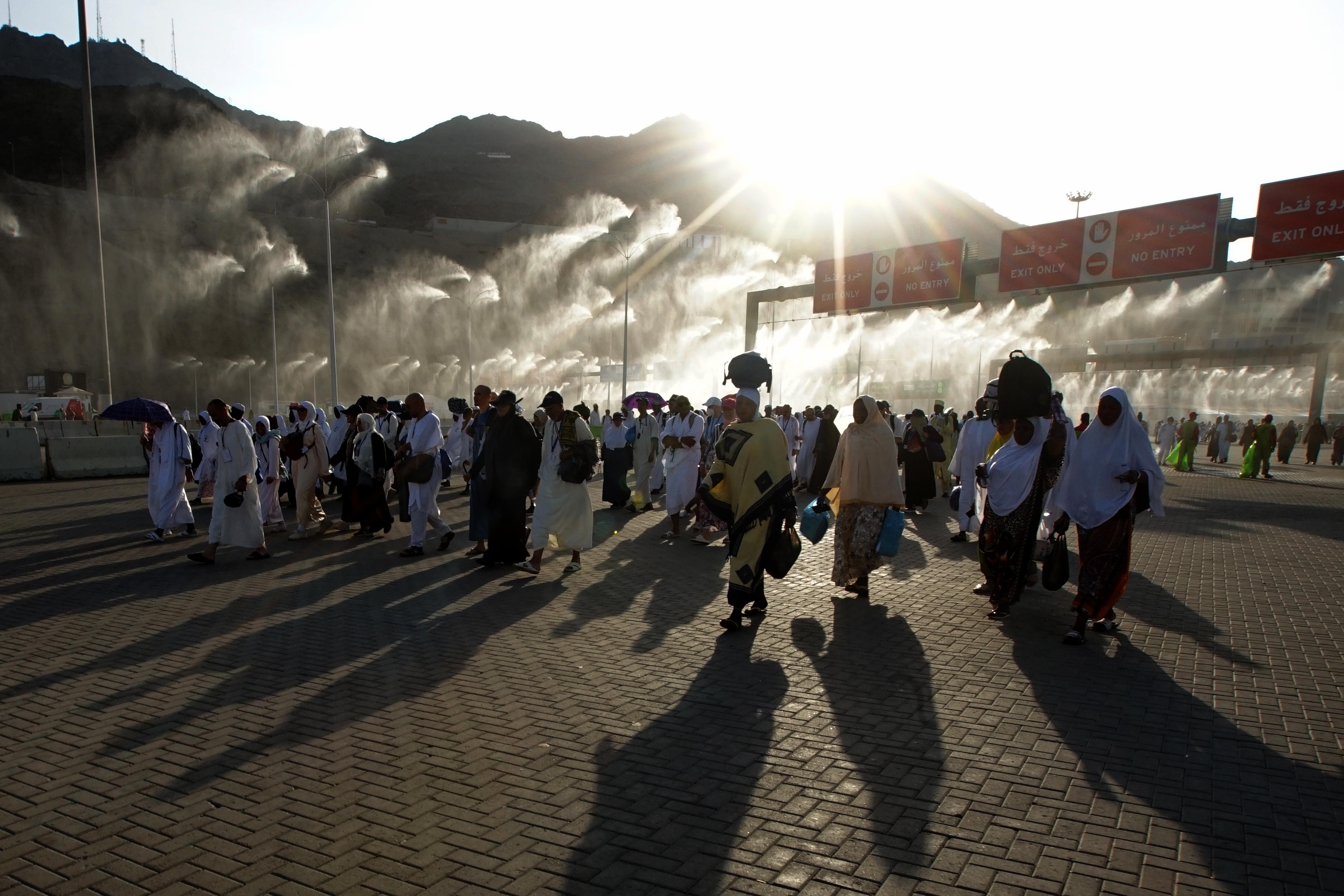 Jemaah haji berjalan melalui gerbang penyemprot air usai melakukan lempar Jumrah di Jamarat, Mina, Mekkah, Arab Saudi, Senin (11/7).