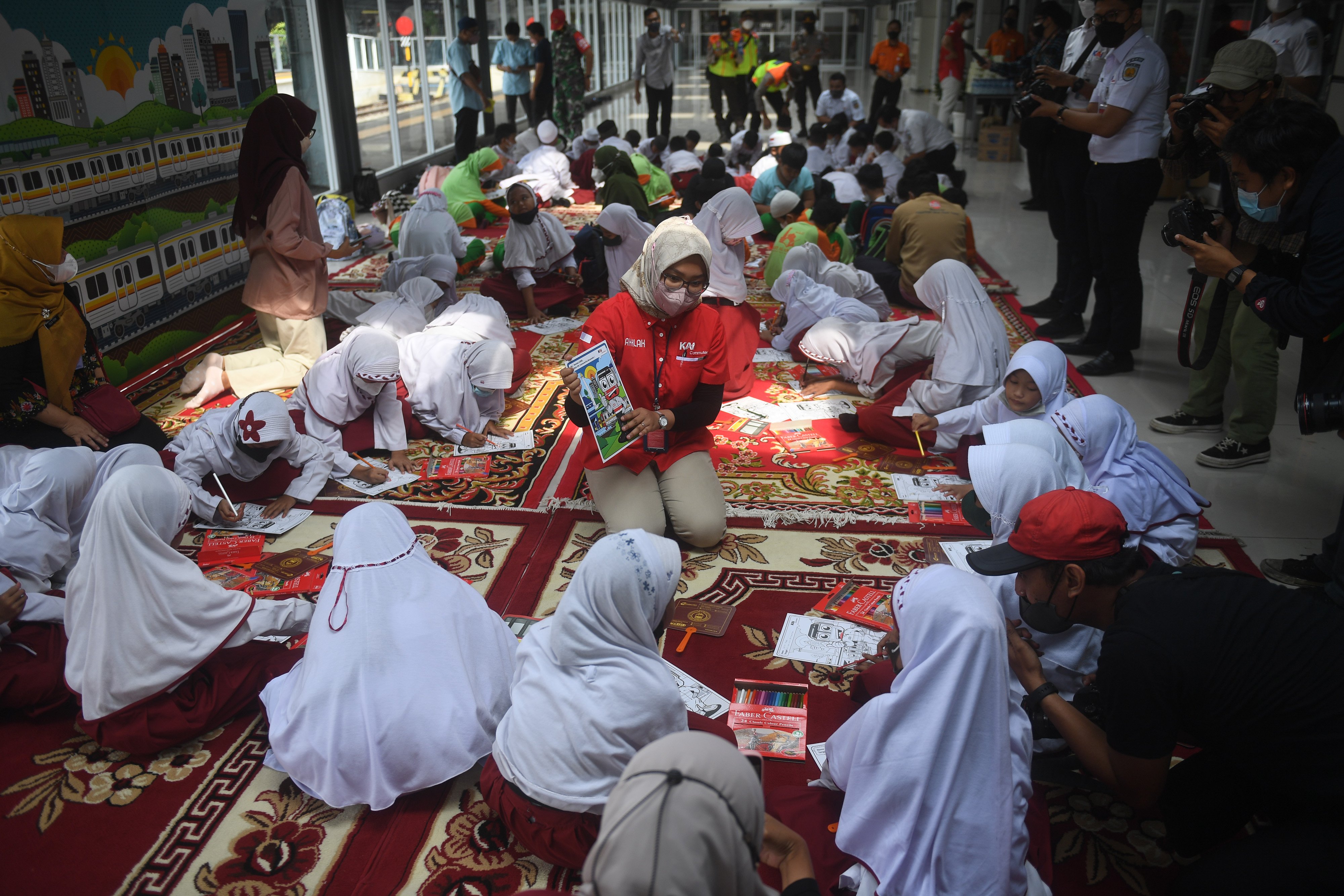 Sejumlah siswa mewarnai gambar bertema transportasi saat perayaan Hari Anak Nasional yang di gelar oleh KAI Commuter 