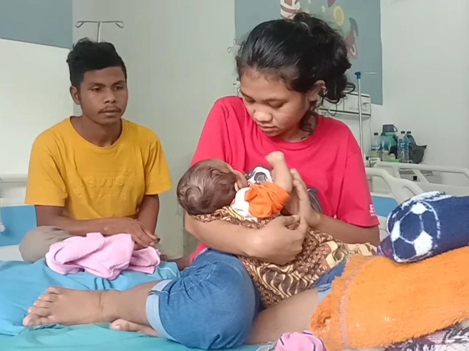 Karolina Fatima Keluru menggendong Cika bersama suami Sabinus. 