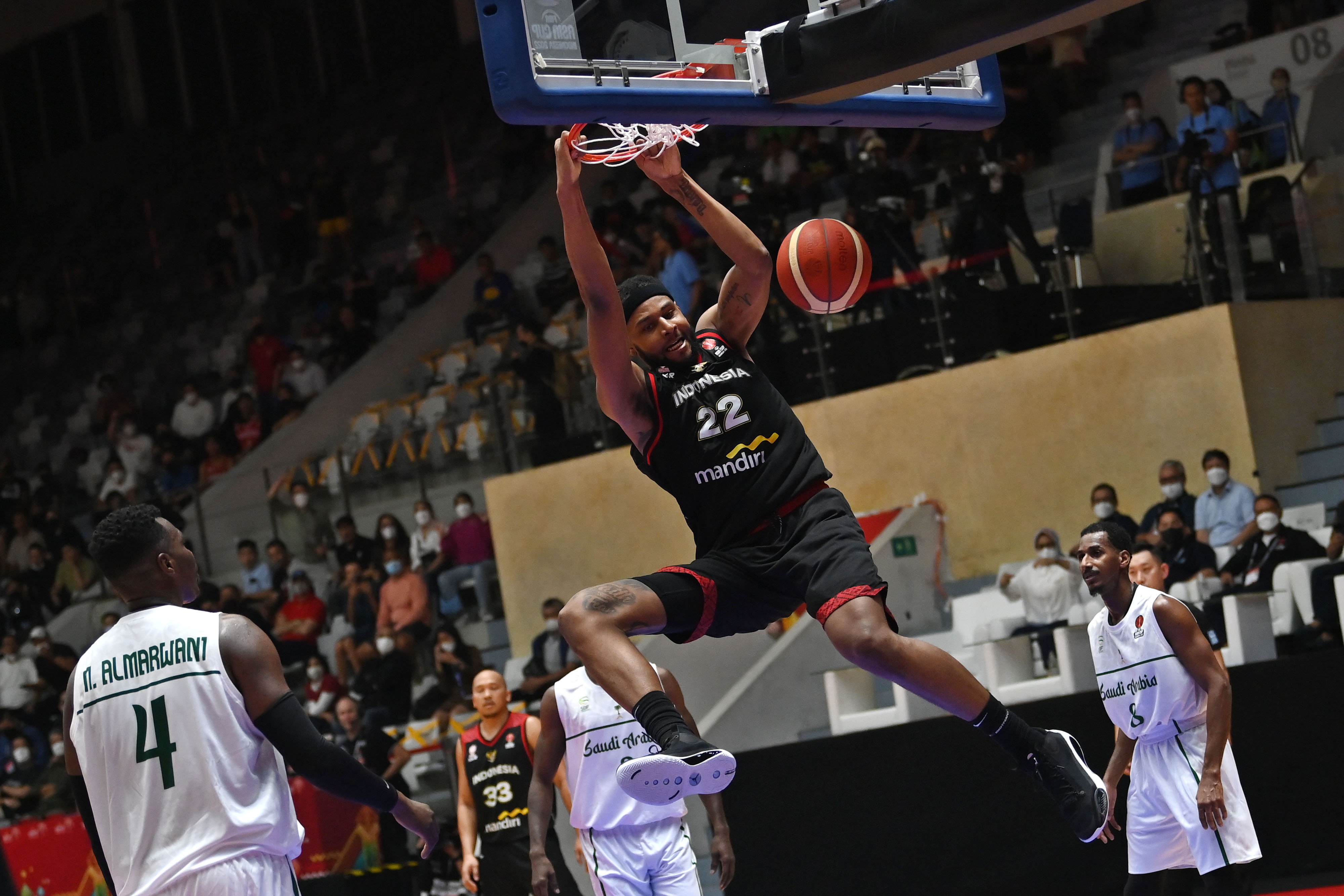 Pemain andalan Timnas Basket Indonesia Marques Bolden melakukan slam dunk ke ring tim Arab Saudi di Istora Senayan Jakarta, Selasa (12/7).