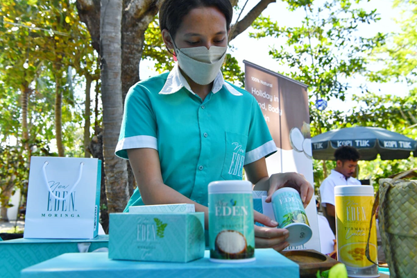 Tampak penjaga stand tengah menunjukkan sejumlah produk olahan daun kelor, Selasa (12/7).