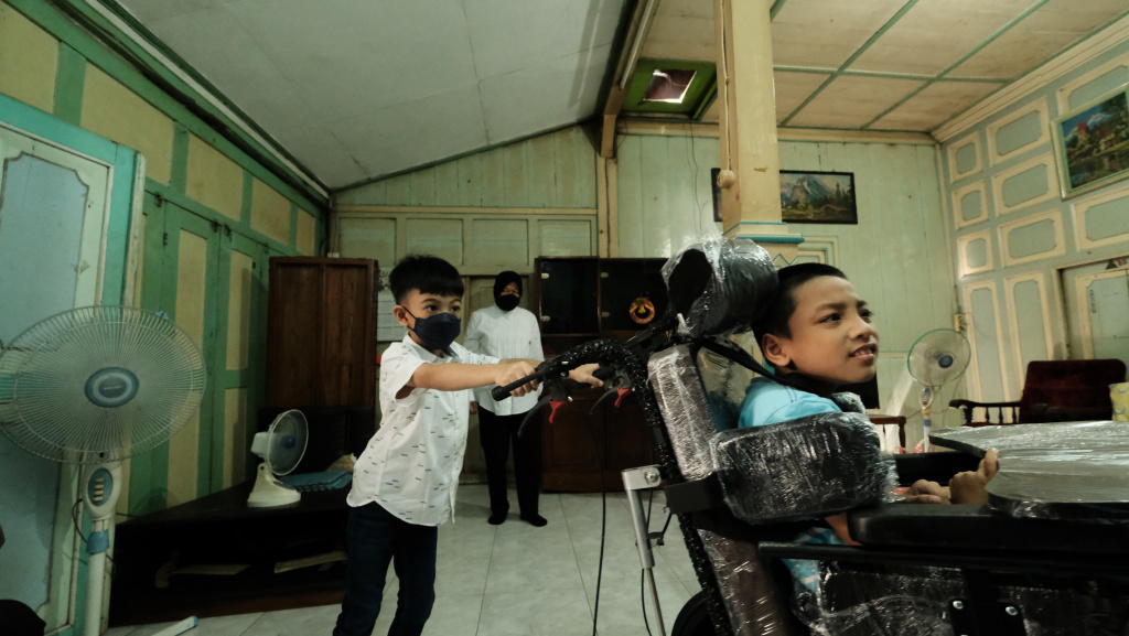 Cucu Presiden Jokowi, Jan Ethes Sinendra membantu mendorong kursi roda adaptif milik Yohanes Gabriel Bayu Pratama, Senin (25/7/20202)
