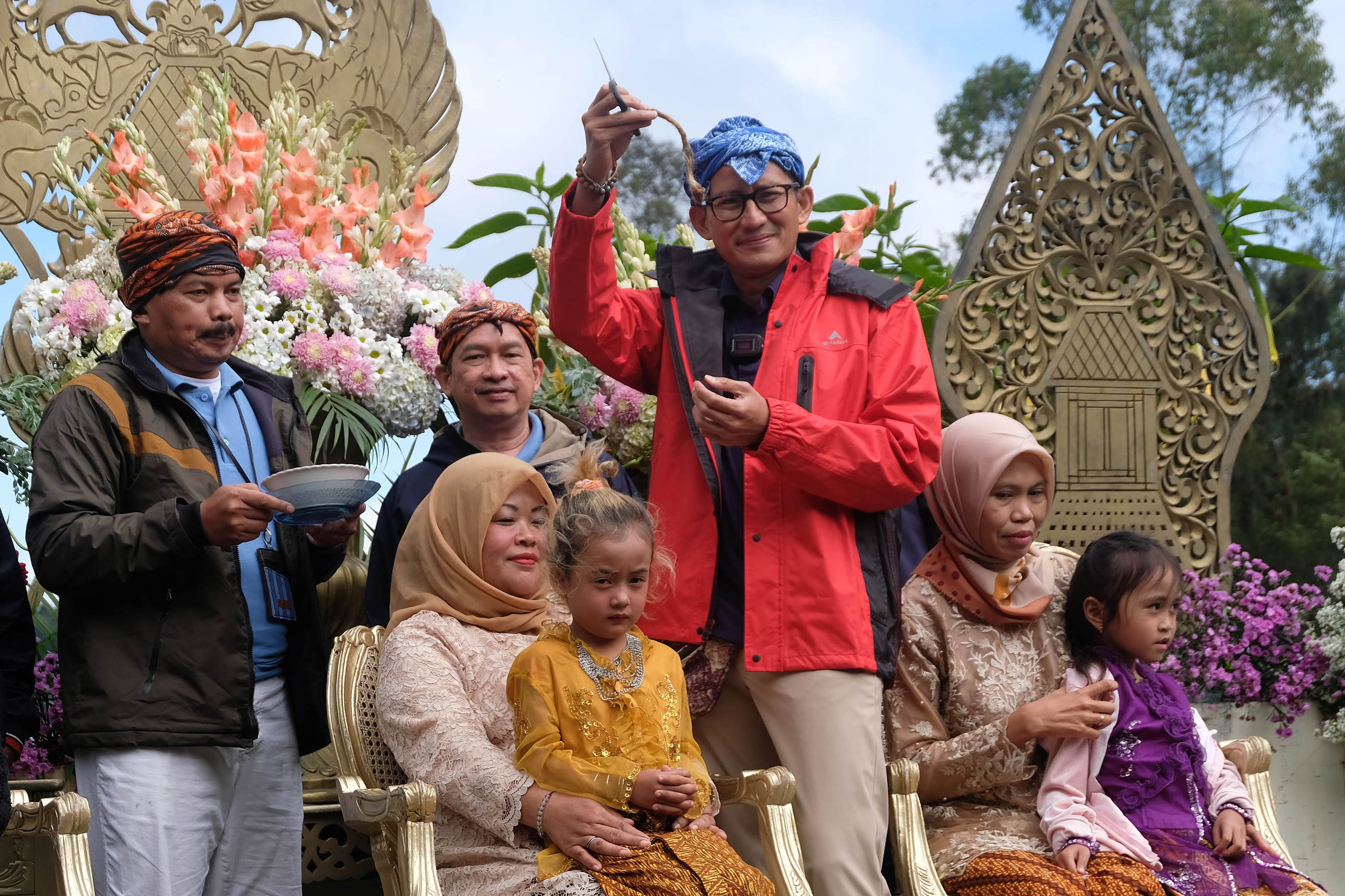 Menparekraf Sandiaga Uno memotong rambut gimbal seorang peserta di Dieng, Jawa Tengah.