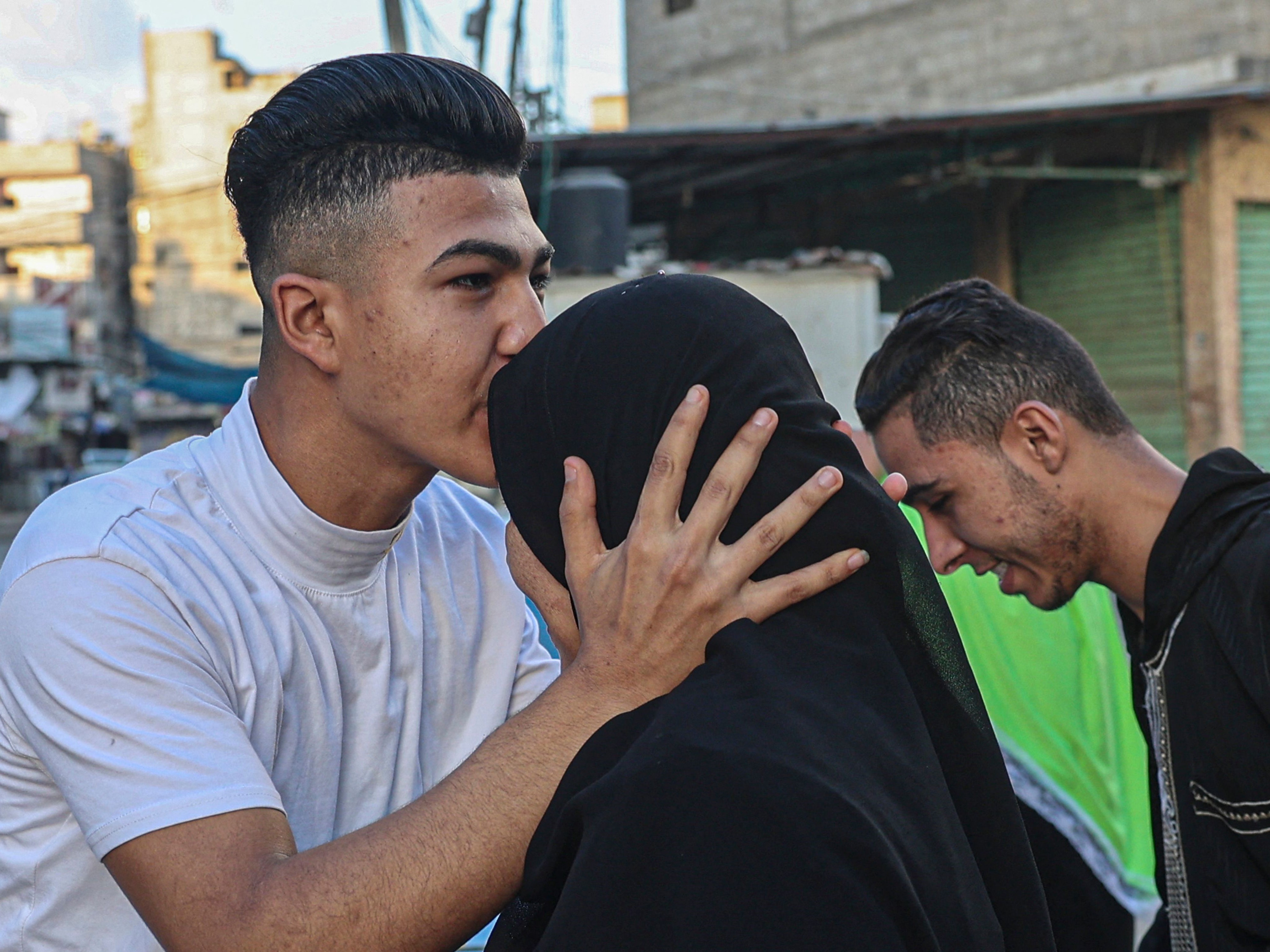 Seorang peziarah Muslim Palestina memeluk seorang kerabat sebelum naik bus di perbatasan Rafah antara Jalur Gaza dan Mesir, 21 Juni 2022.