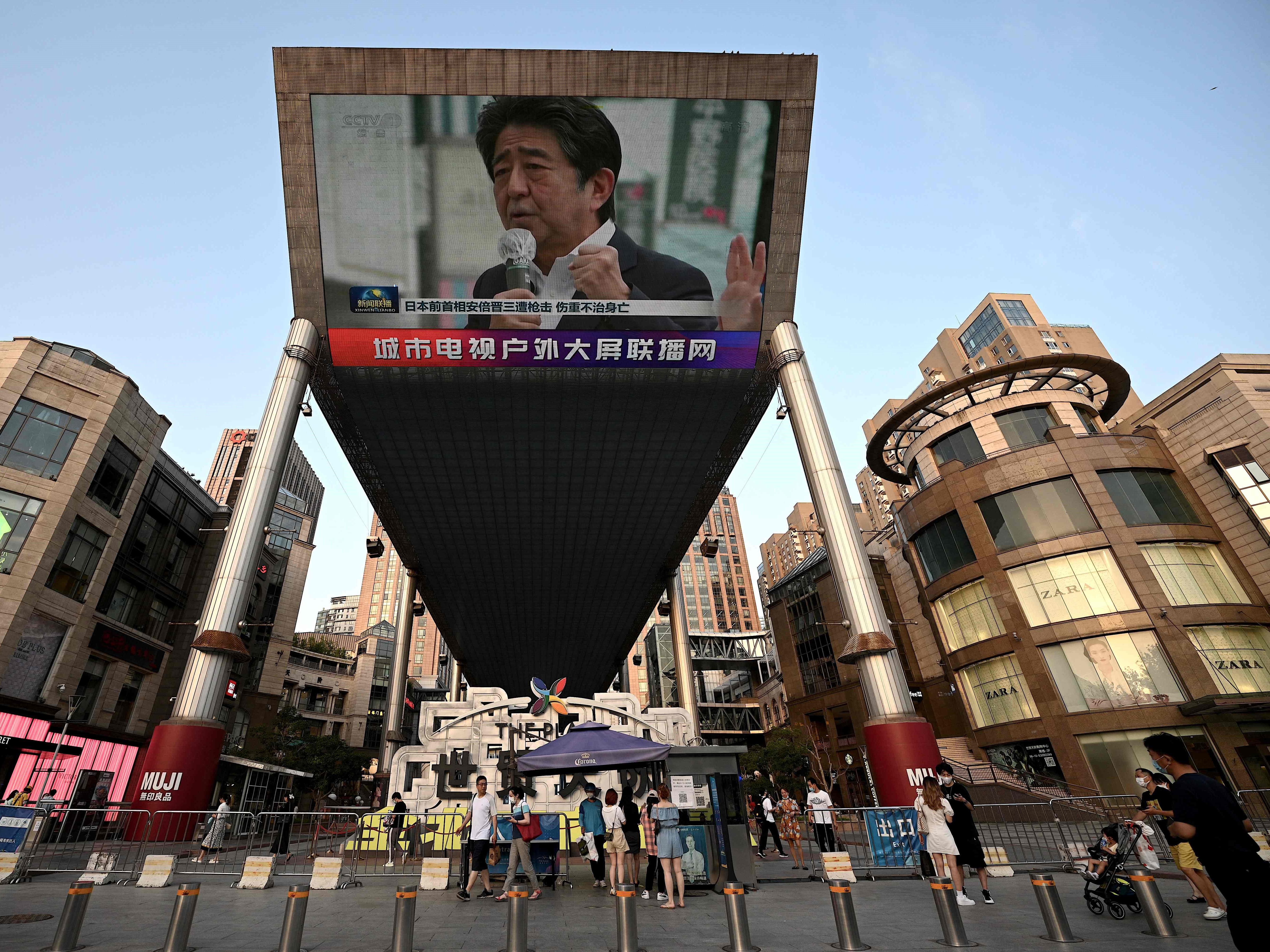 Layar video besar menunjukkan siaran berita yang menampilkan gambar mantan perdana menteri Jepang Shinzo Abe di Beijing, Jumat (8/7). 