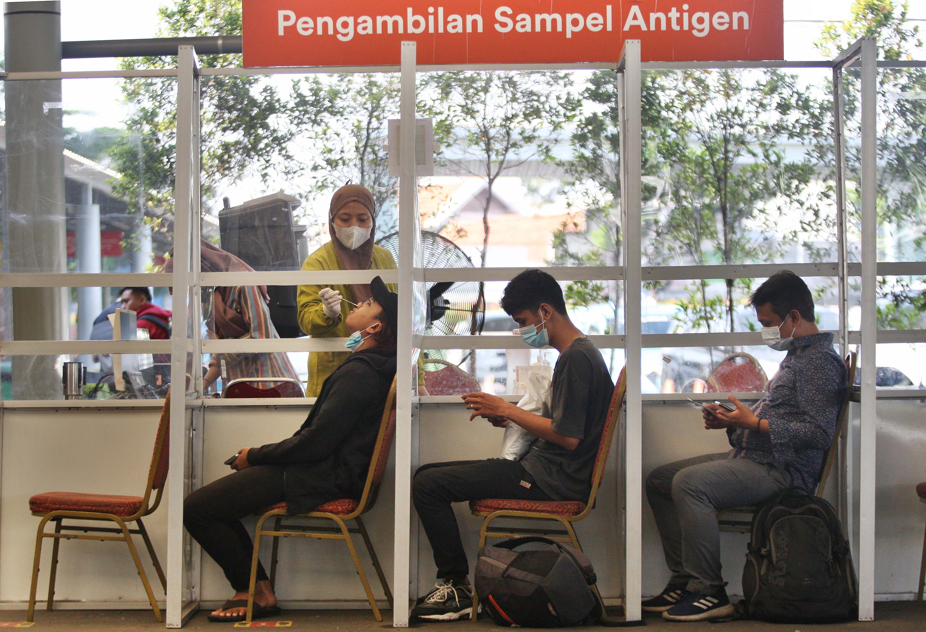 Calon penumpang menjalani tes antigen sebelum vaksinasi booster di Stasiun Pasar Senen, Jakarta