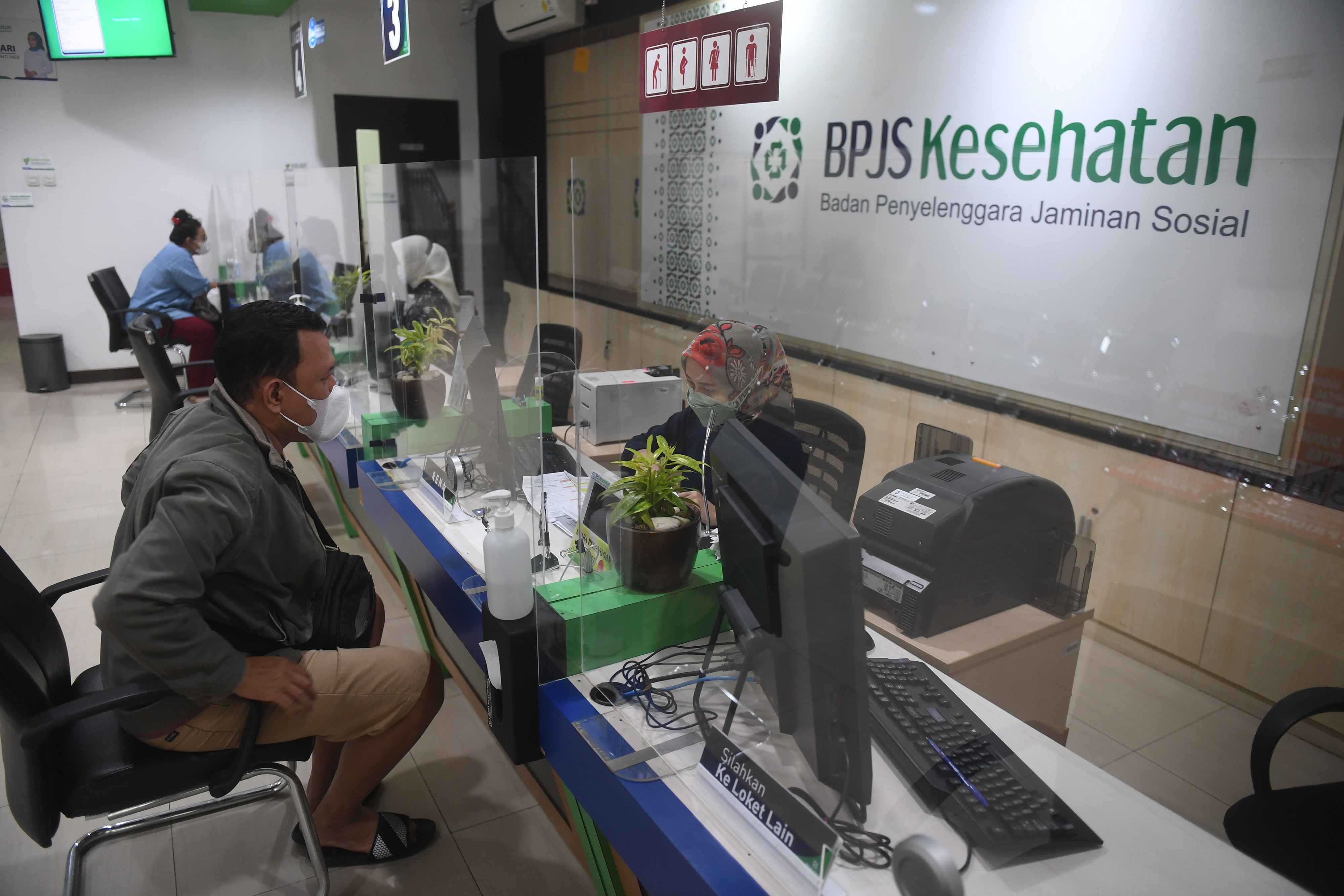 Petugas melayani warga di loket BPJS Kesehatan Jakarta Pusat, Jakarta.