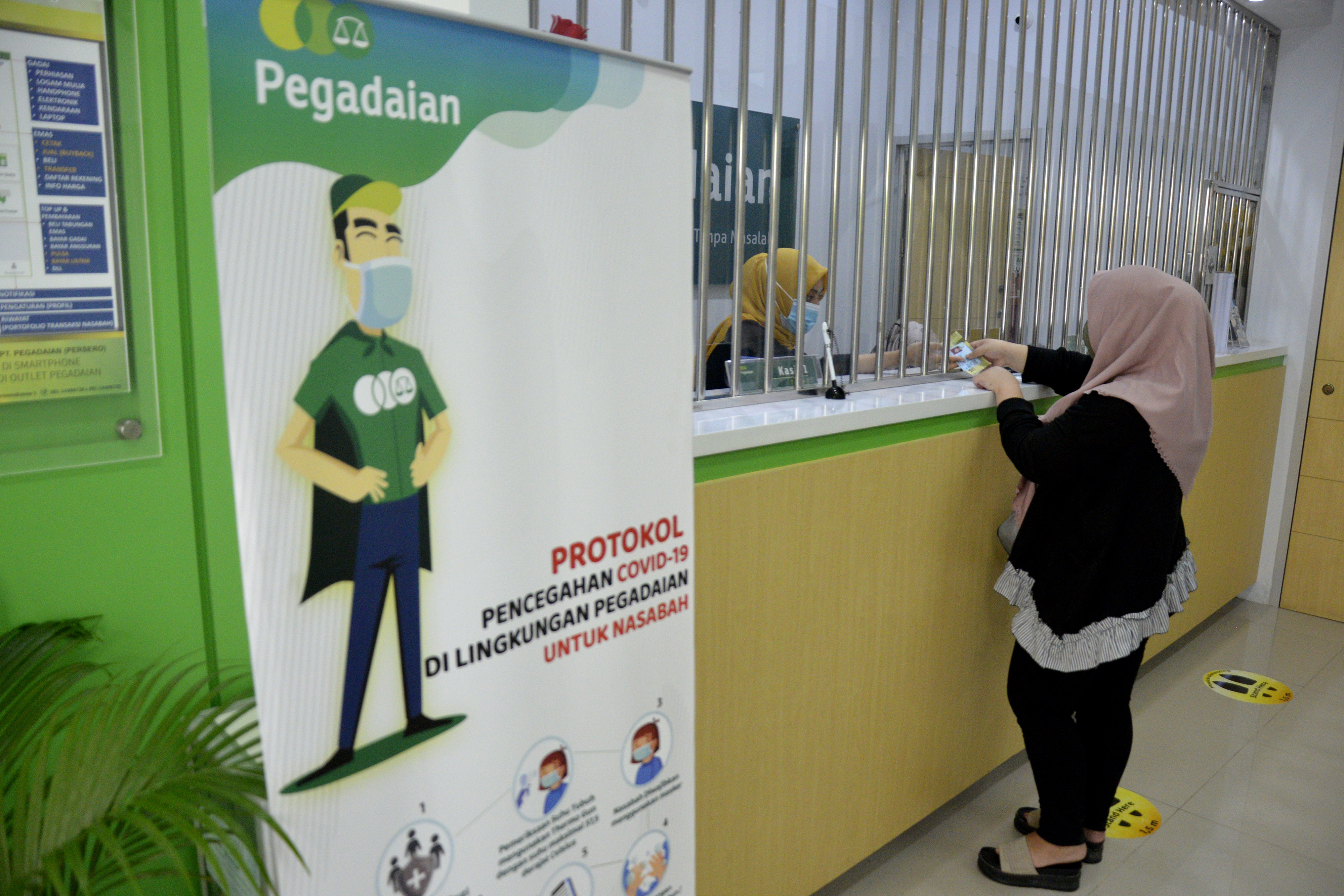 Karyawan Pegadaian saat melayani nasabah di kantor wilayah Makassar, Sulawesi Selatan.