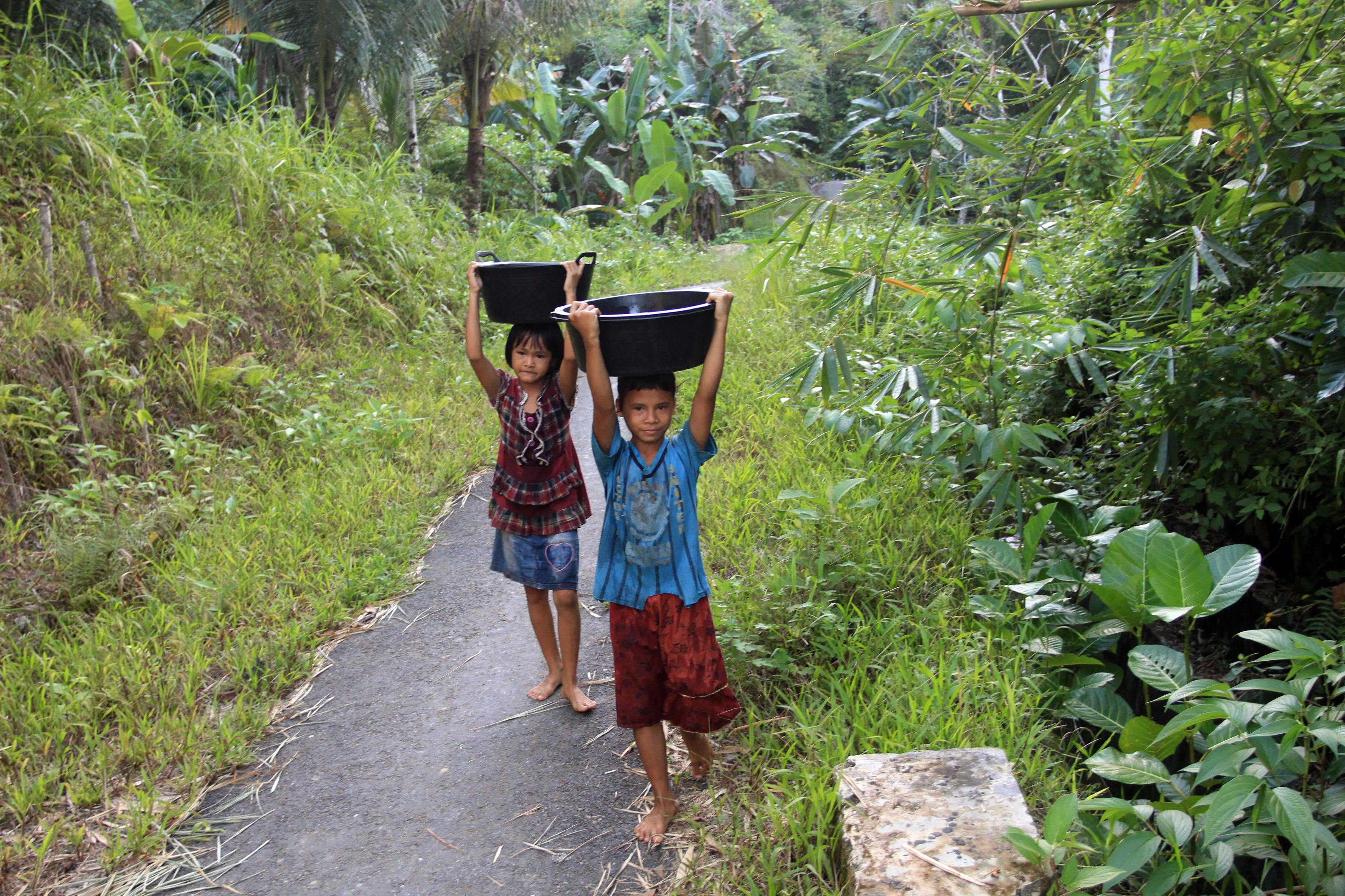 Potret anak-anak mengangkat ember berisi asir di wilayah Nias, Sumatera Utara.