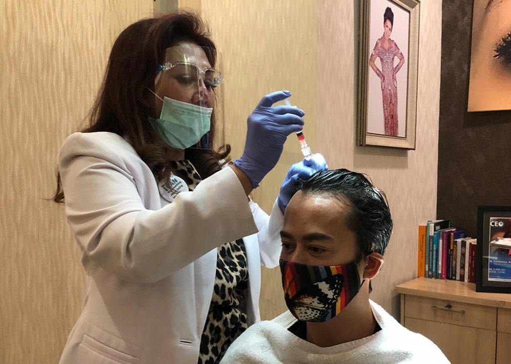 Ahli transplantasi rambut dr. Farmanina melakukan penanaman rambut pada pasiennya. 