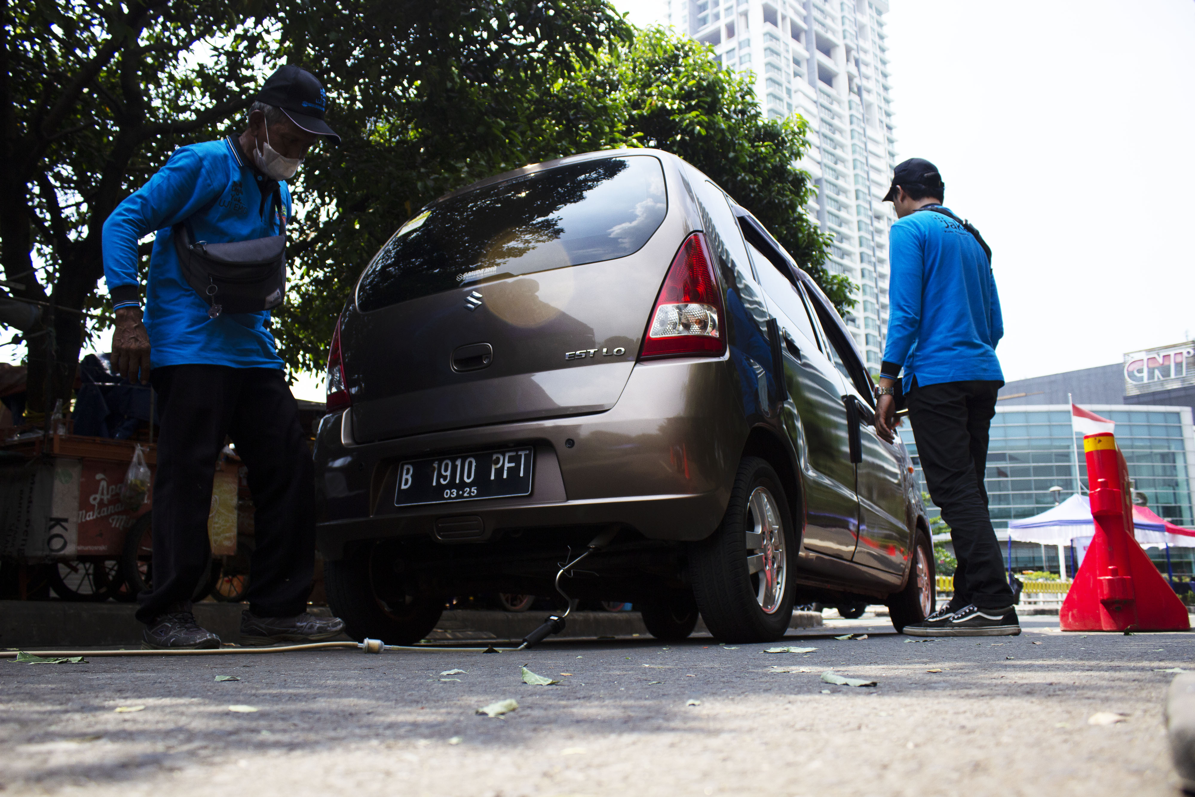 Petugas melakukan uji emisi kendaraan di Jakarta.