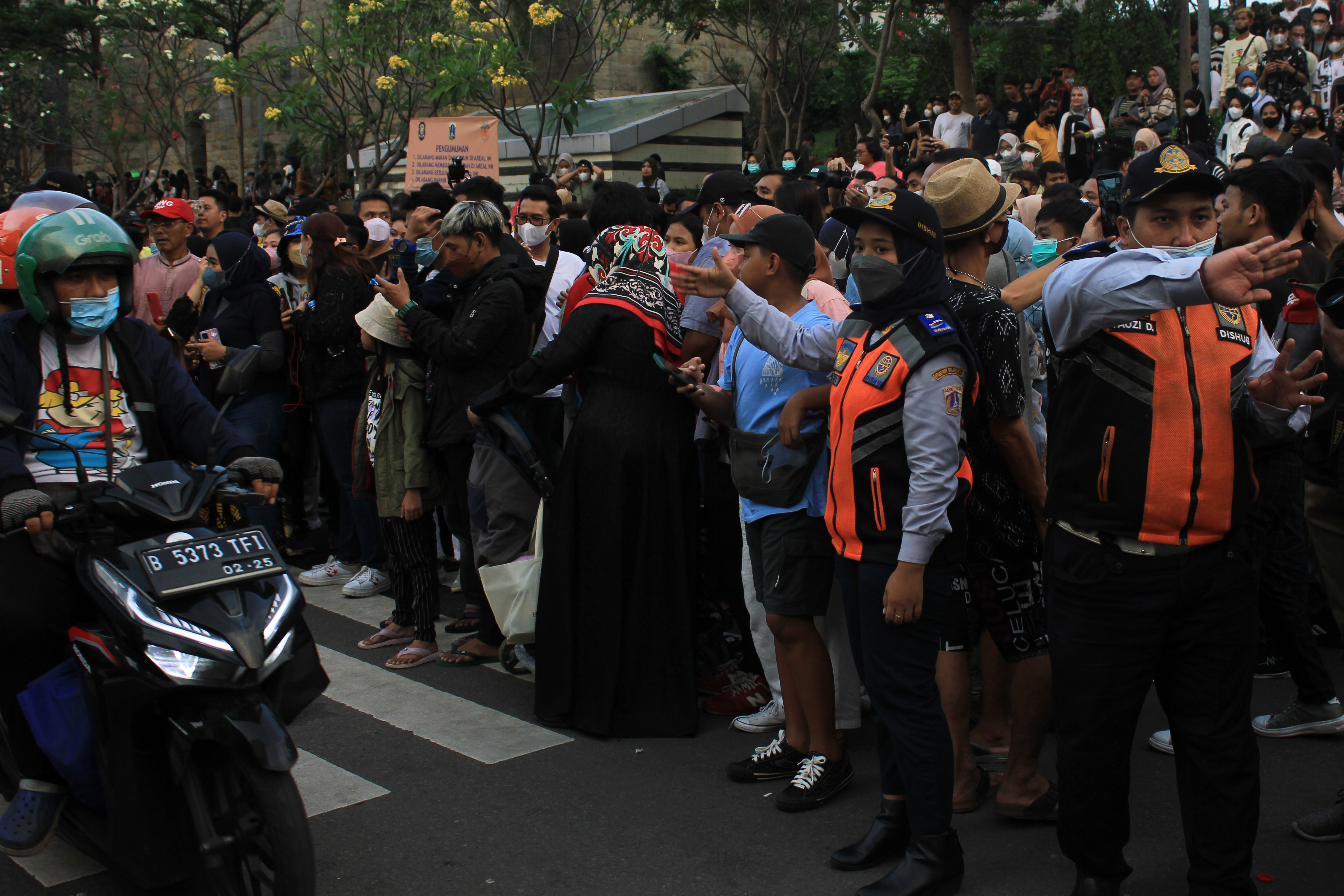 Dua petugas Dinas Perhubungan mengatur arus lalu lintas di kawasan Dukuh Atas, Jakarta, Minggu (24/7).