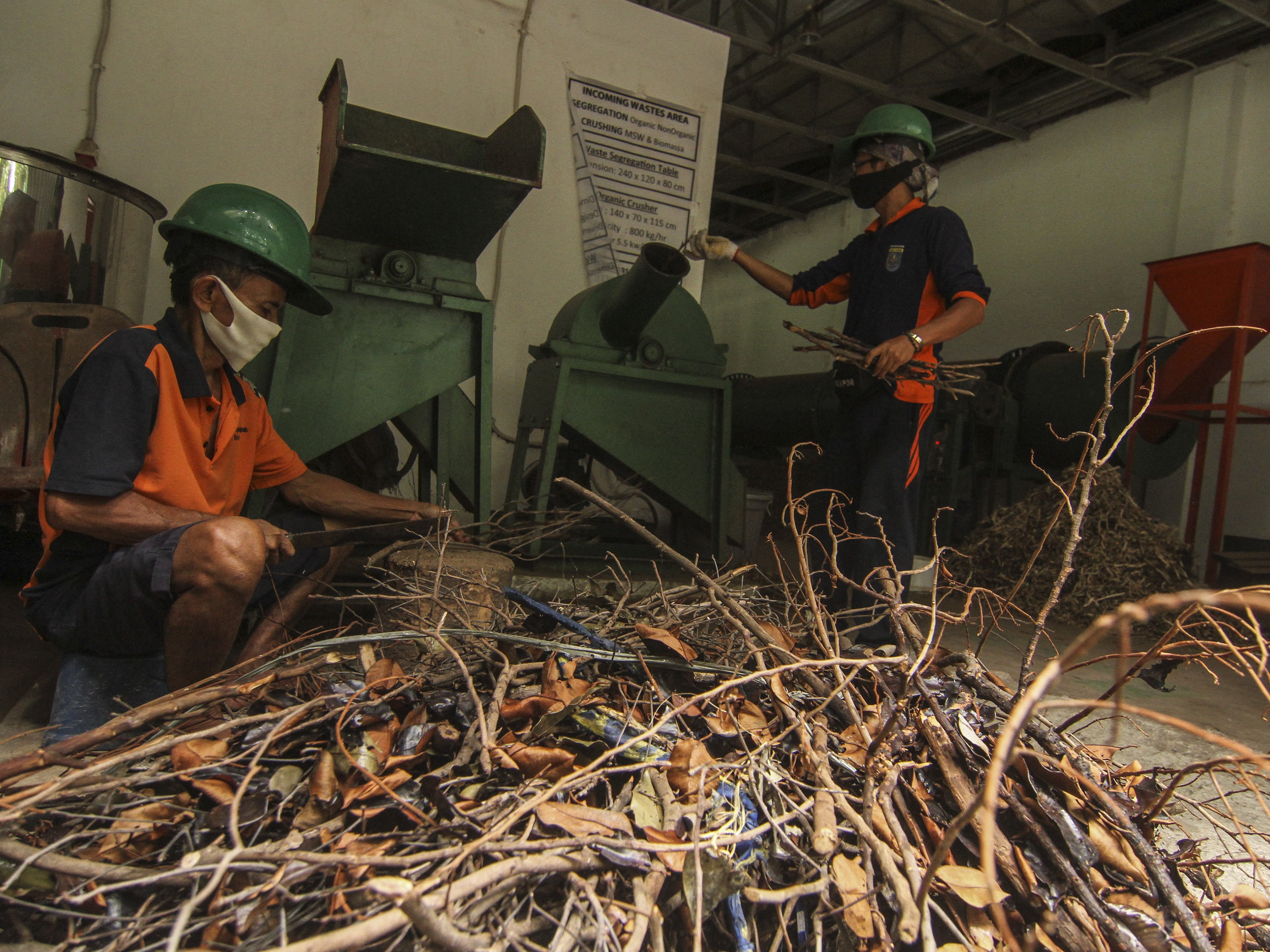 Pekerja mengolah limbah kayu atau ranting pohon menjadi pelet kayu di Tempat Pengolahan Sampah Setempat, Sukmajaya, Depok, Jabar.
