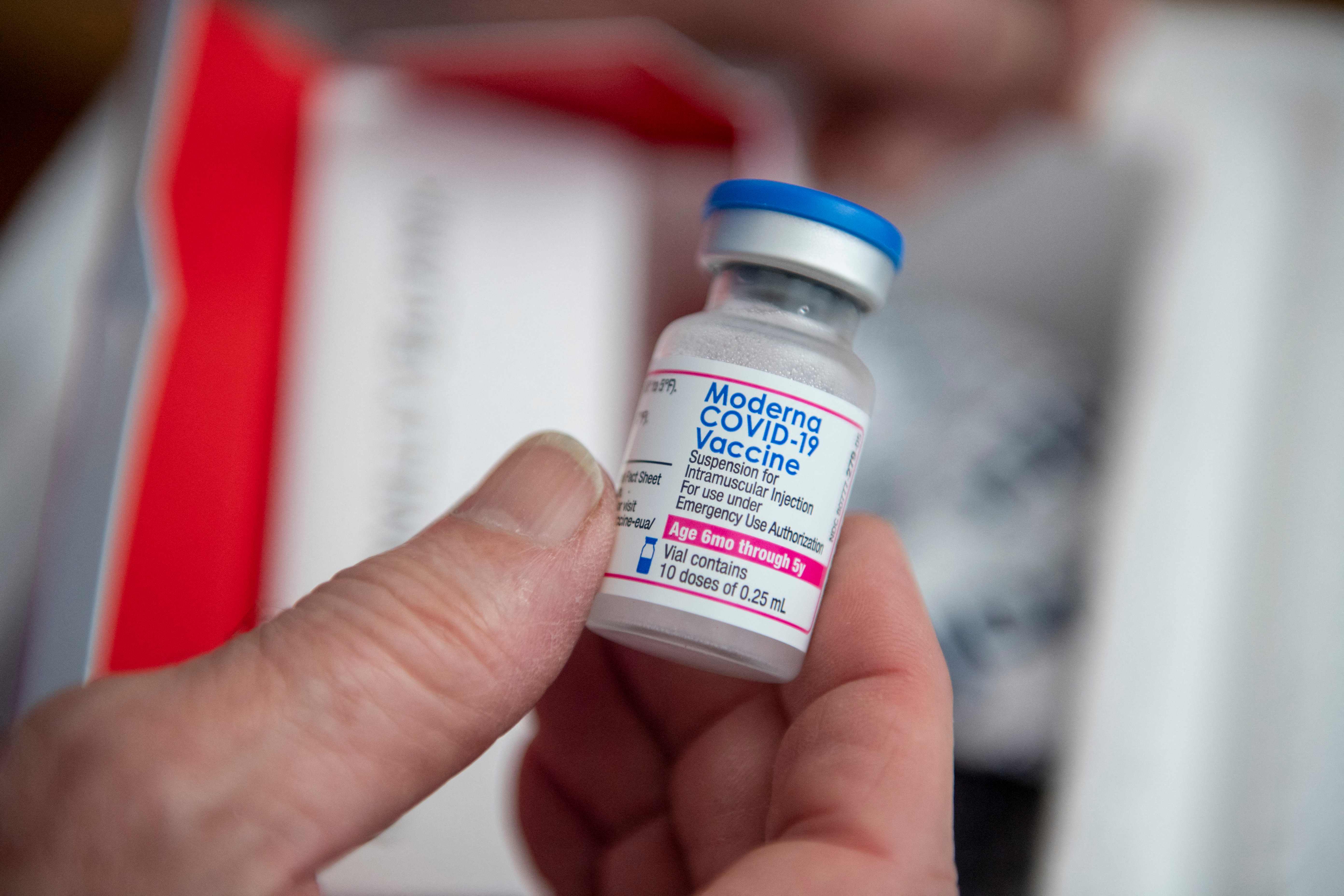 Seorang nakes menunjukkan botol berisi vaksin covid-19 buatan Moderna.