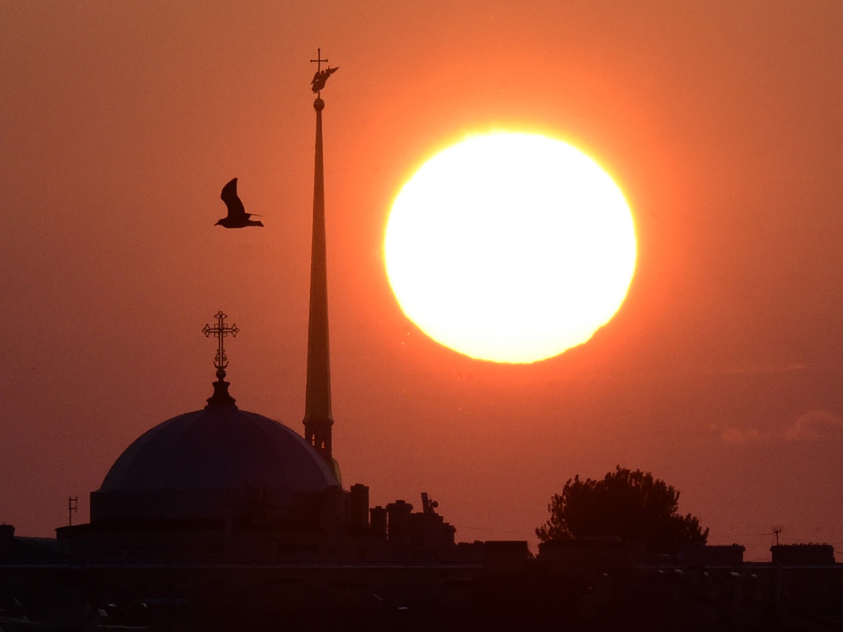 Matahari terbit di balik puncak menara Katedral Peter and Paul di Saint Petersburg, Rusia, pada awal 21 Juli 2022.