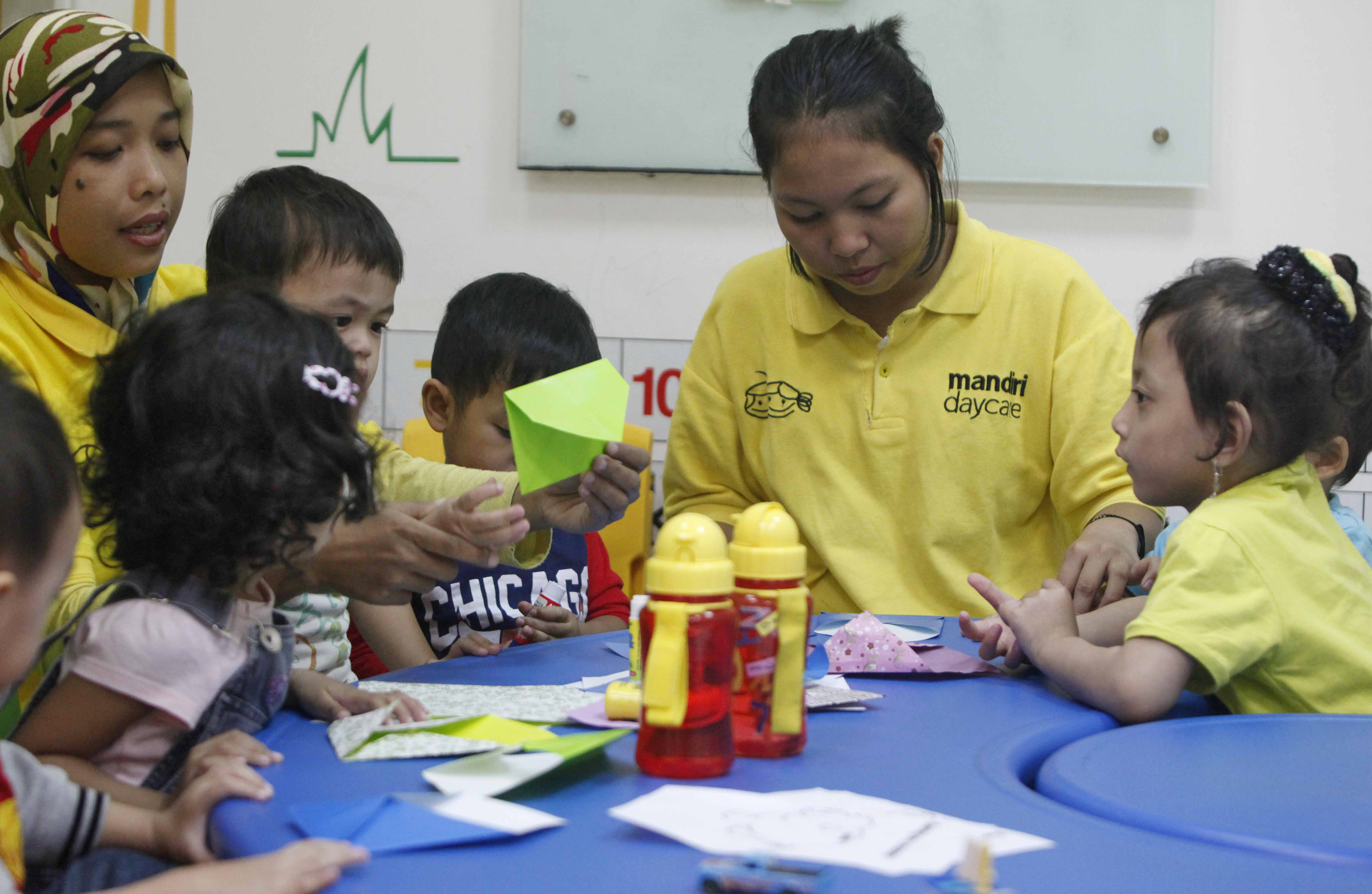 Anak-anak didampingi petugas beraktifitas di Mandiri Daycare di Plaza Mandiri, Jakarta.
