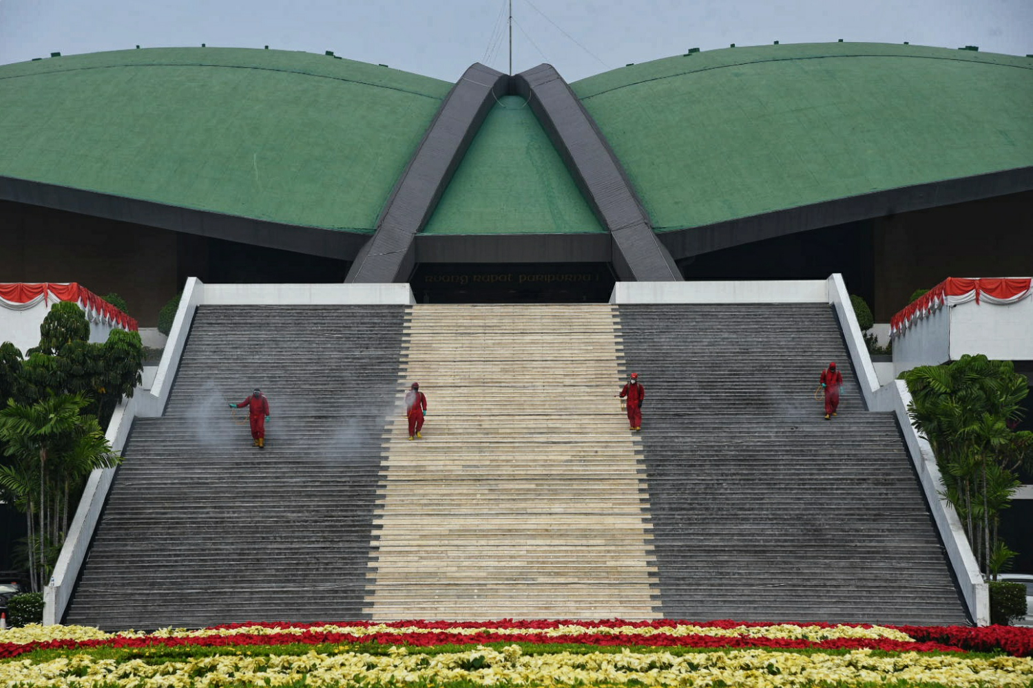 Petugas menyemprotkan cairan disinfektan di sekitar Kompleks Parlemen, Jakarta.