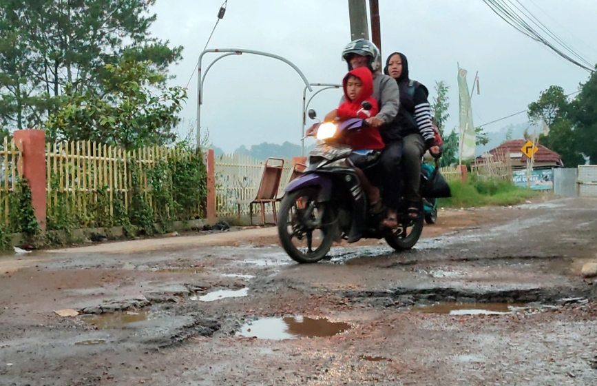 Pengendara bermotor menghindari jalan berlubang di Jalan Kinderdolf Lembang, Kabupaten Bandung Barat.
