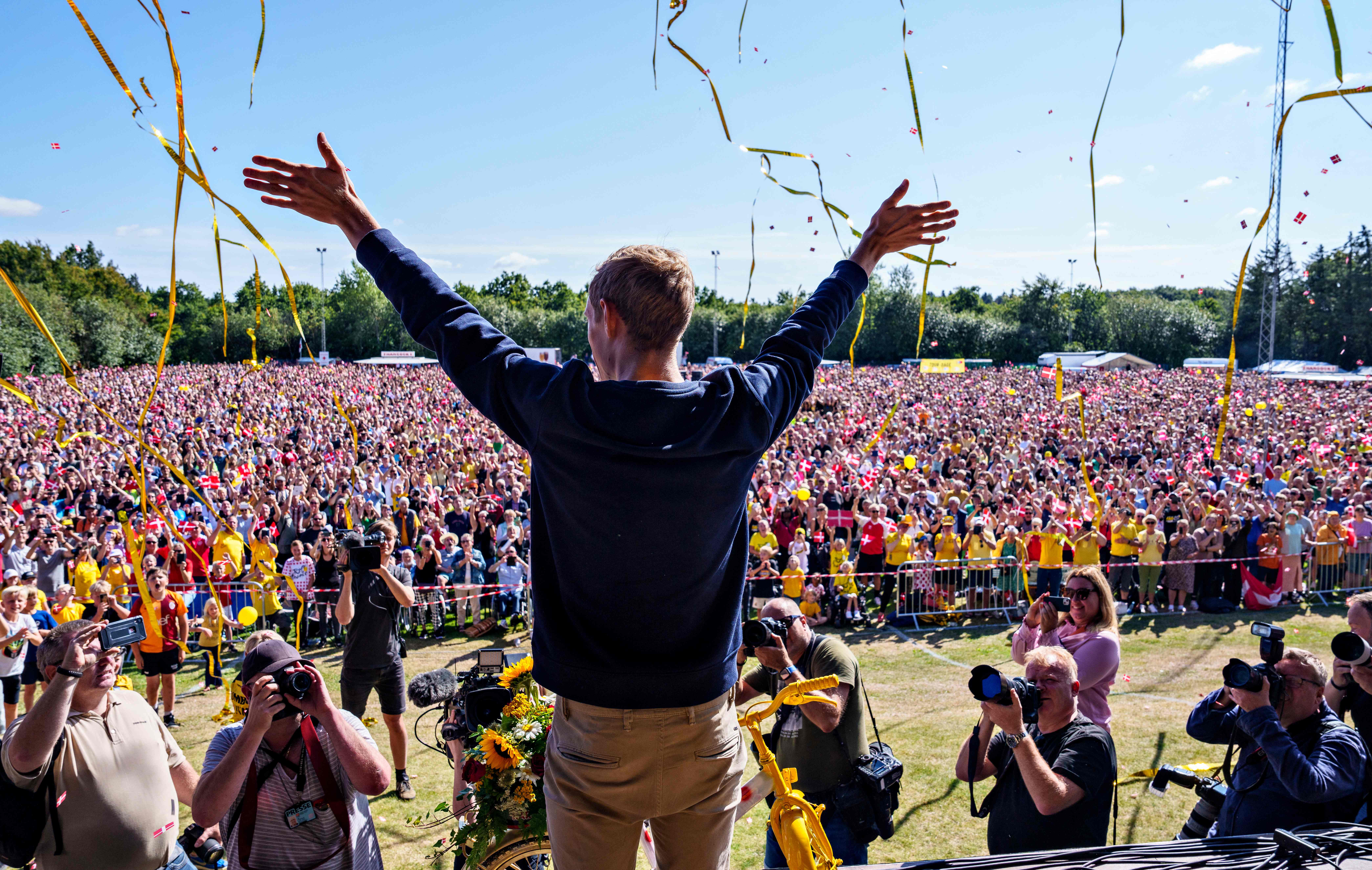 Juara Tour de France Jonas Vingegaard melambaikan tangan kepada warga yang menyambutnya di desa tempat tinggalnya, Glyngore.