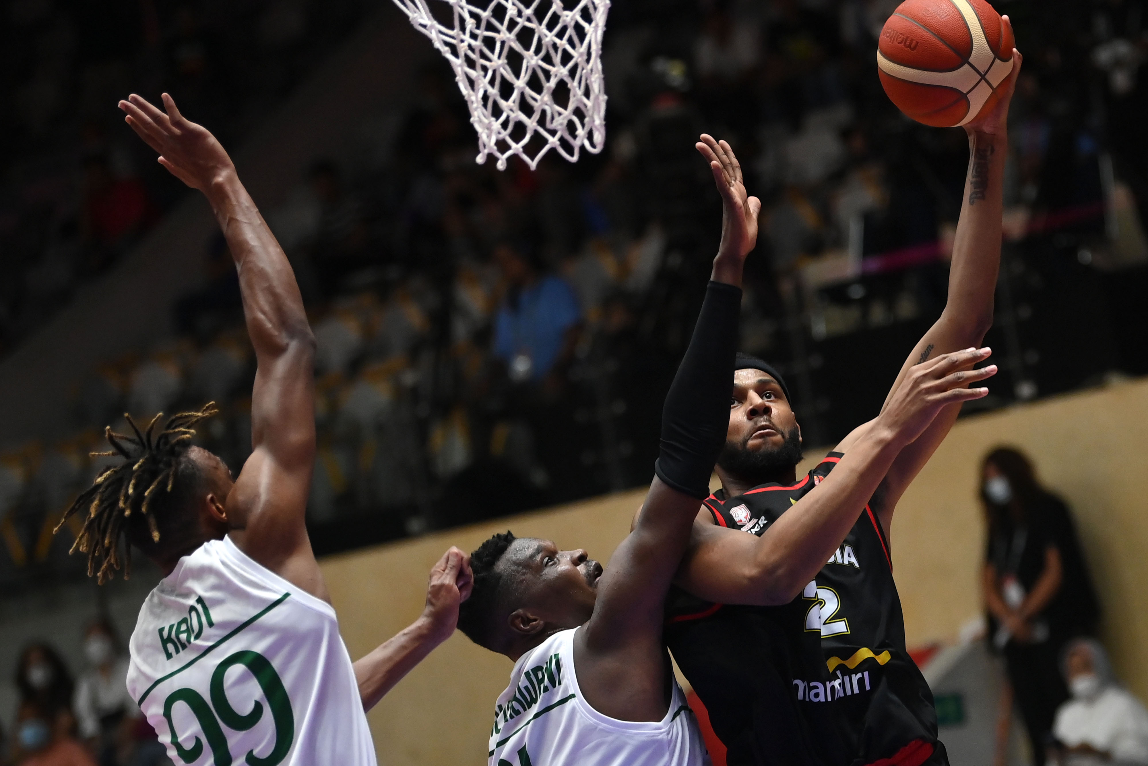 Pebasket Indonesia Marques Bolden melewati hadangan dua pemain Arab Saudi pada laga perdana Grup A FIBA Asia Cup 2022, Selasa (12/7).