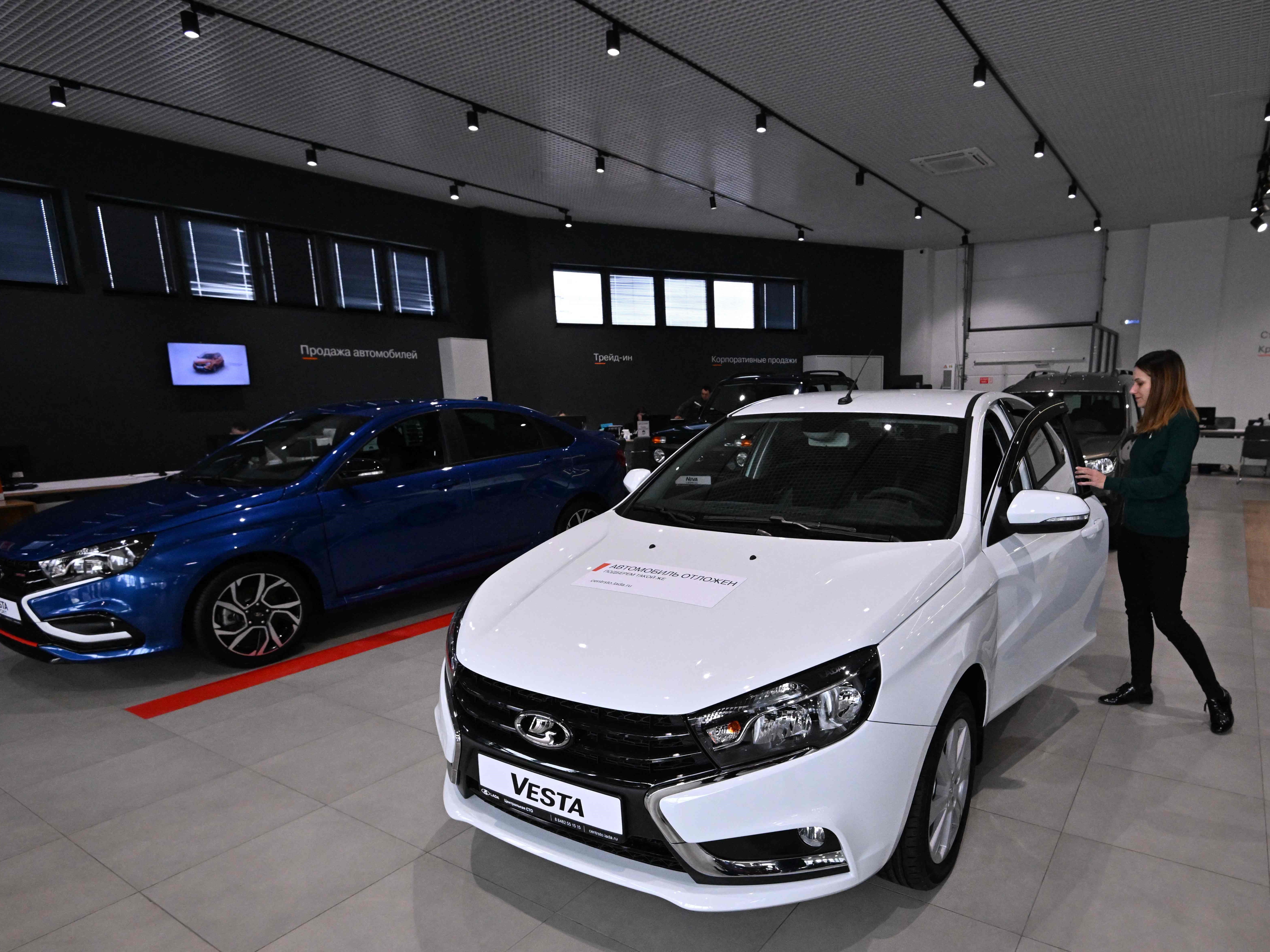 Seorang manajer membuka pintu mobil Lada Vesta di showroom dealer mobil Lada di Tolyatti, Rusia, pada 1 April 2022.