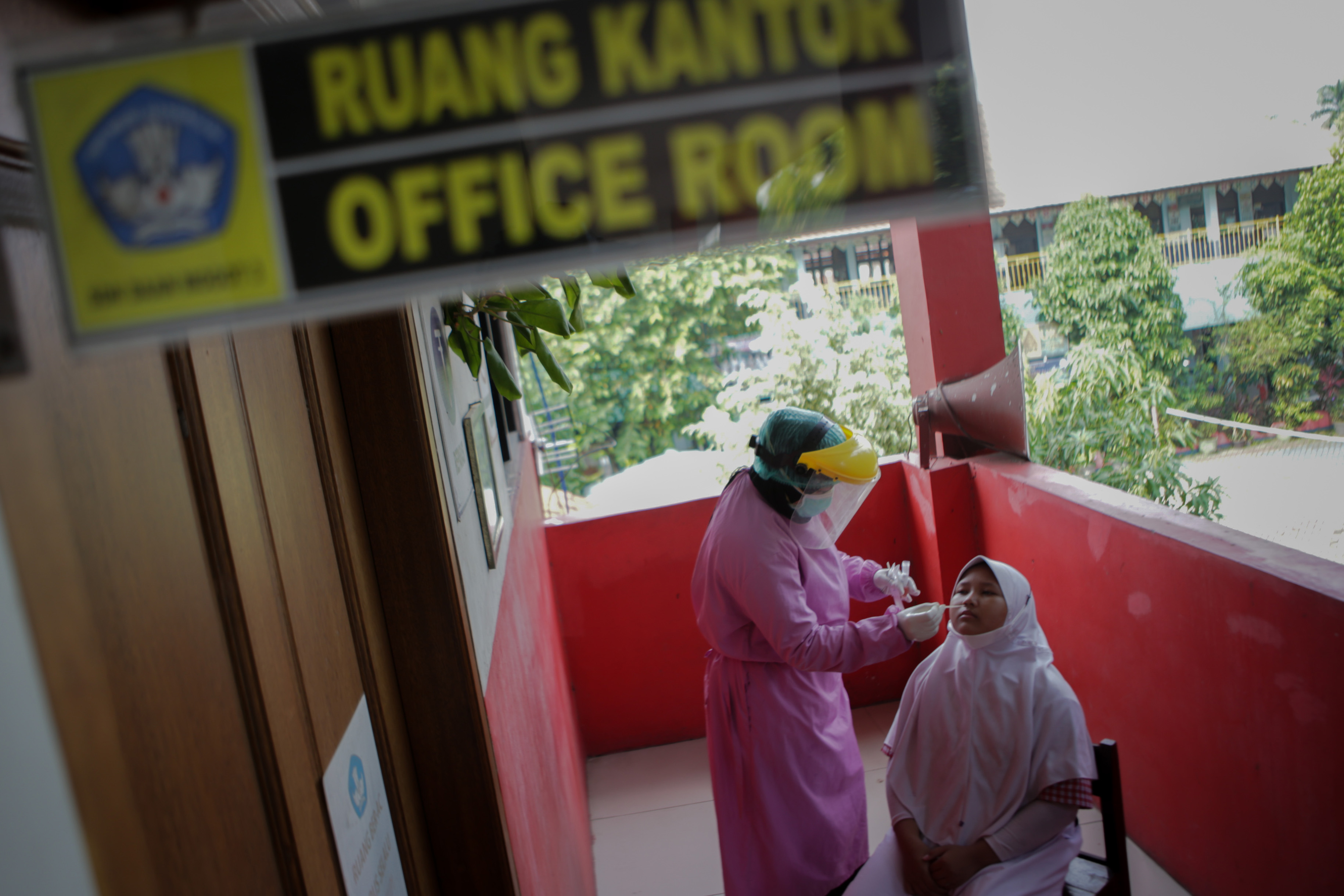  Petugas kesehatan melakukan tes usap PCR kepada siswa di SDN Daan Mogot 3, Kota Tangerang, Banten, Kamis (19/5/2022