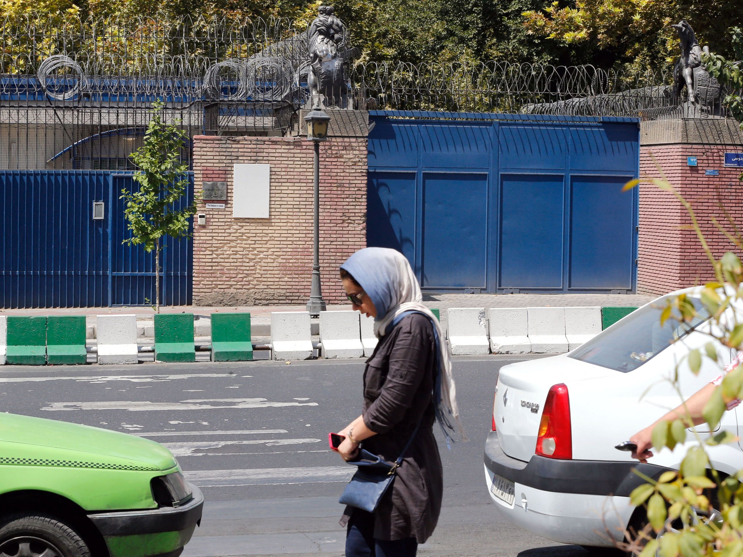 Seorang wanita Iran berjalan melewati kedutaan Inggris yang saat itu ditutup di ibu kota Teheran, beberapa waktu lalu.
