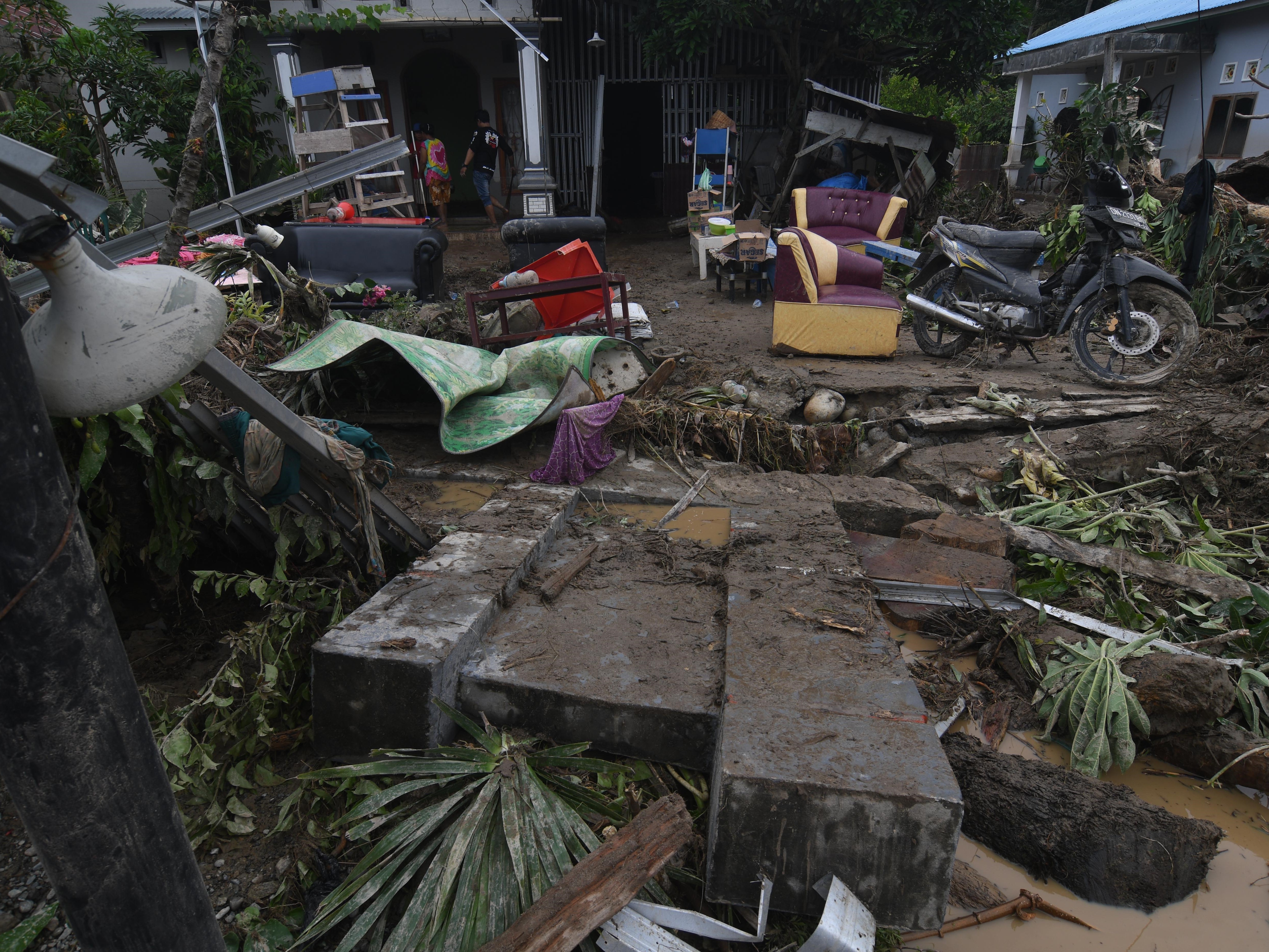 Warga berada di sekitar rumah yang rusak akibat diterjang banjir bandang di Desa Torue, Kabupaten Parigi Moutong, Sulteng, Jumat (29/7).
