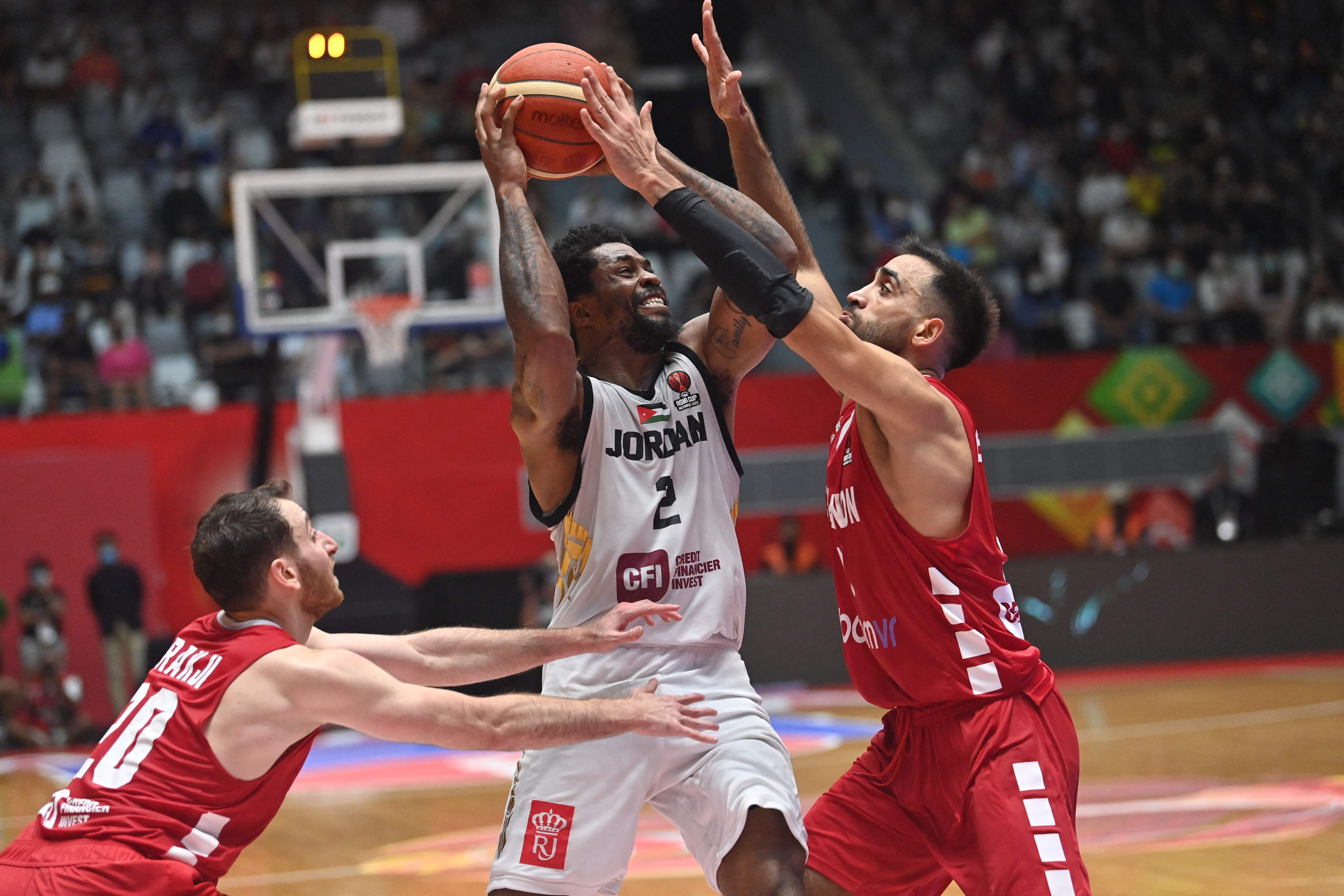 Pemain Yordania Dar Tucker (tengah) dikawal dua pemain Lebanon dalam laga semifinal FIBA Asia Cup 2022 di Senayan, Sabtu (23/7).