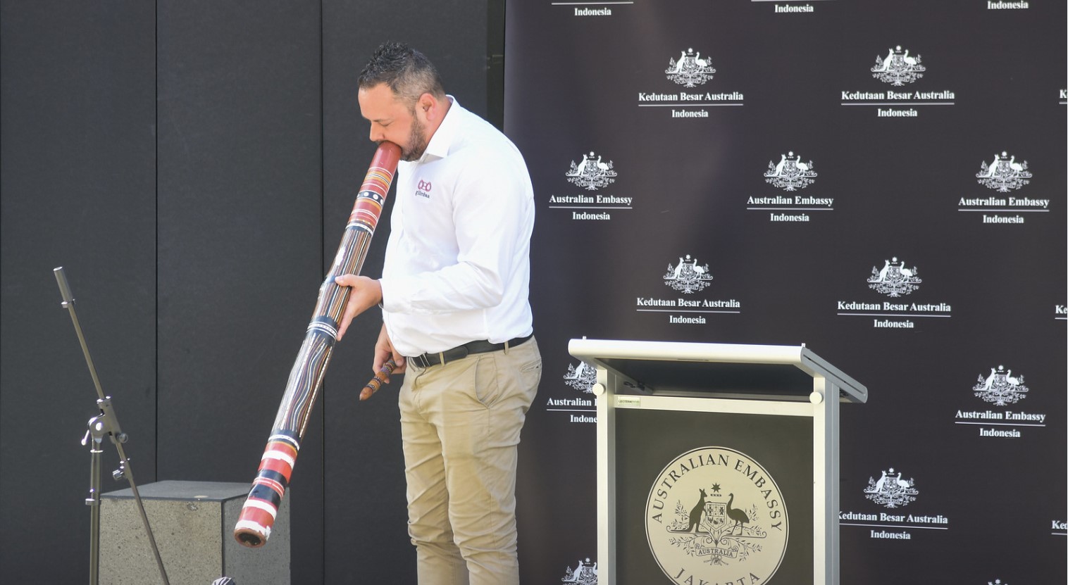 Penduduk asli Australia terkemuka, David Williams memain alat musik tradisional Australia didgeridoo.