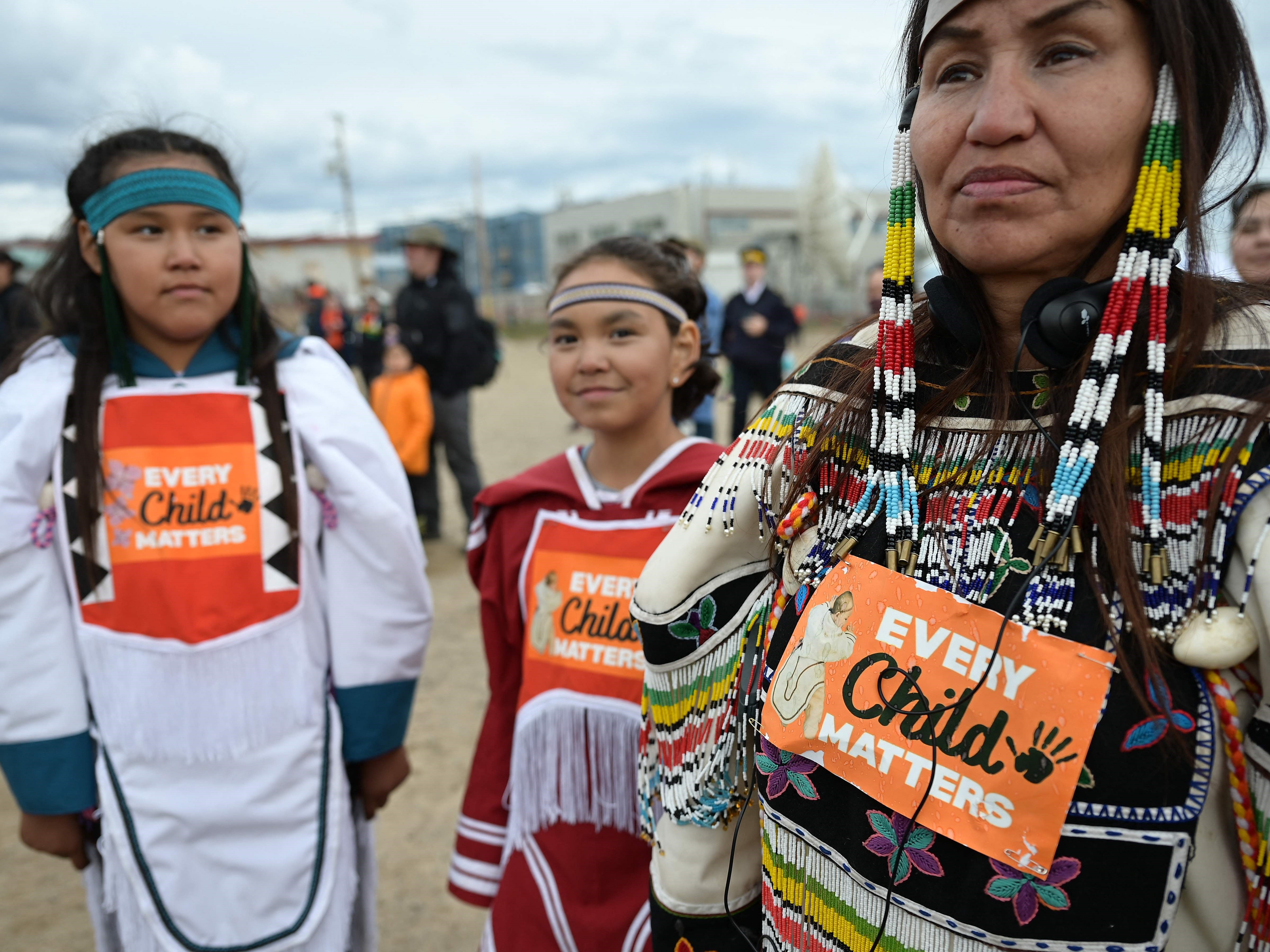 Wanita pribumi mengenakan Every Child Matters di pakaian saat menunggu kedatangan Paus Fransiskus di sekolah Nakasuk di Iqaluit, Kanada.