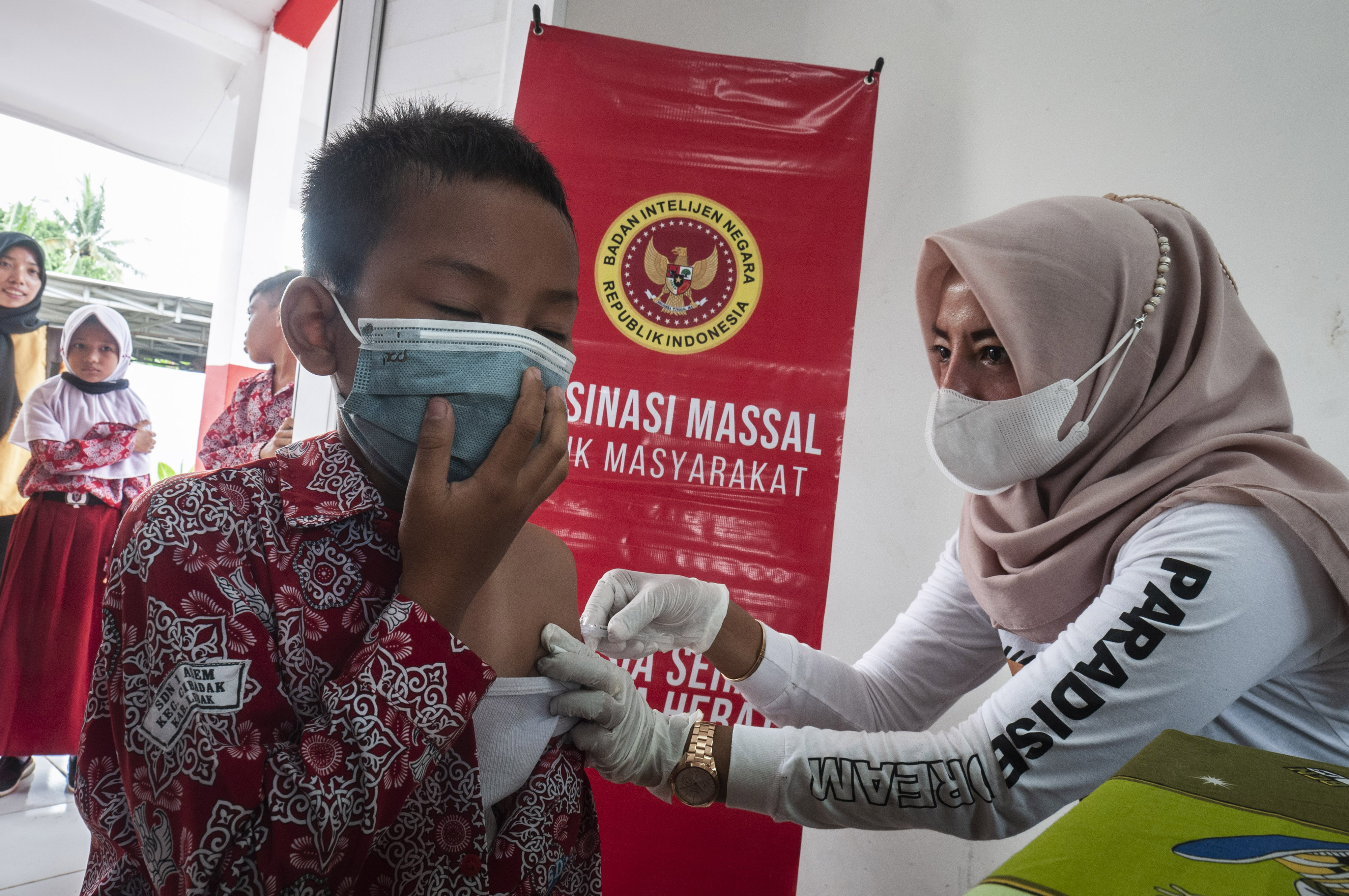 Siswa SD menerima suntikan vaksin covid-19 dari petugas kesehatan.