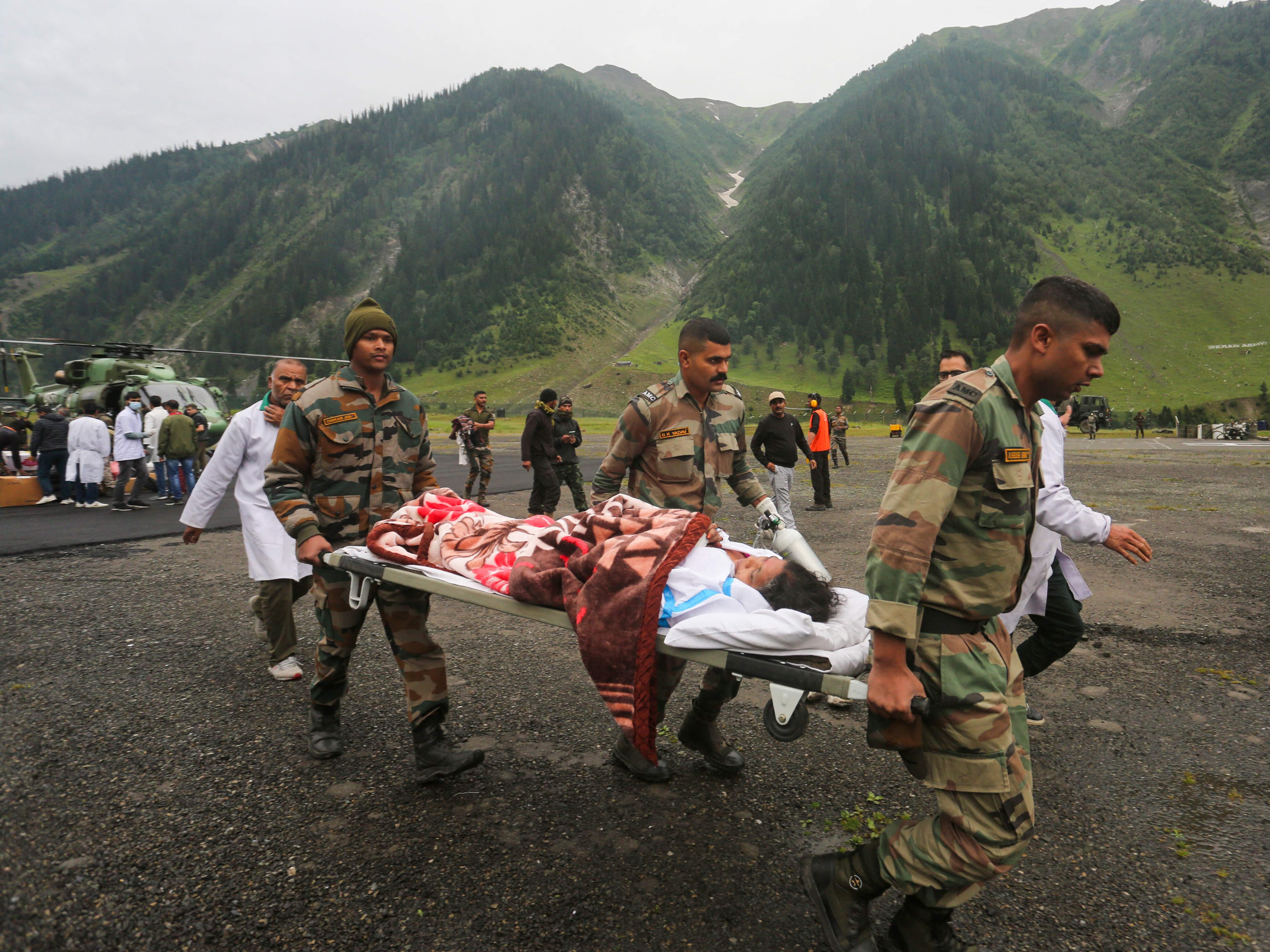 Tentara membawa korban banjir bandang selama ziarah Amarnath dekat base camp Baltal di Kashmir pada 9 Juli 2022.