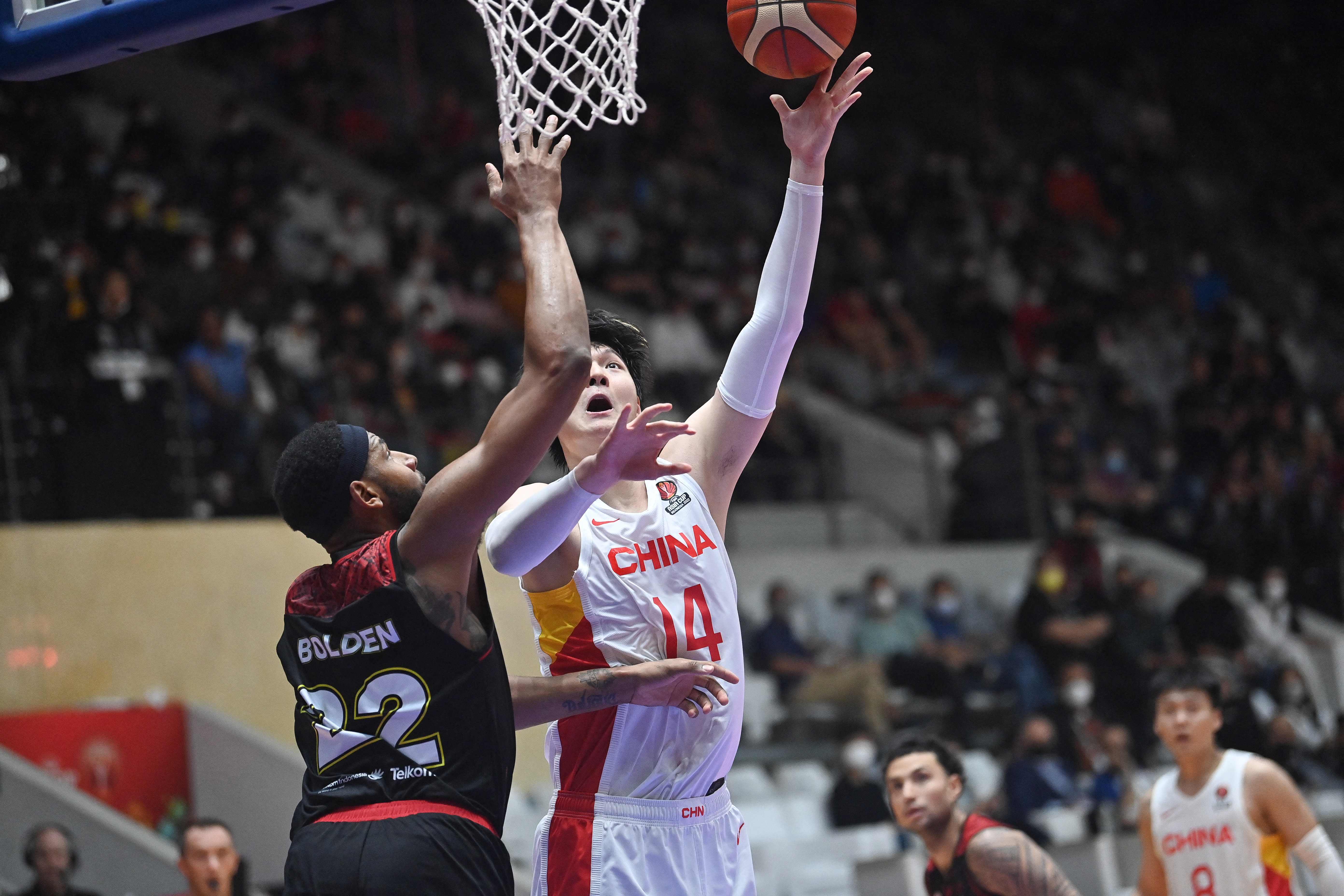 Pebasket Indonesia  Marques Terrel Bolden (kiri) mencoba menghalangi pebasket Tiongkok Sun Minghui (kanan)