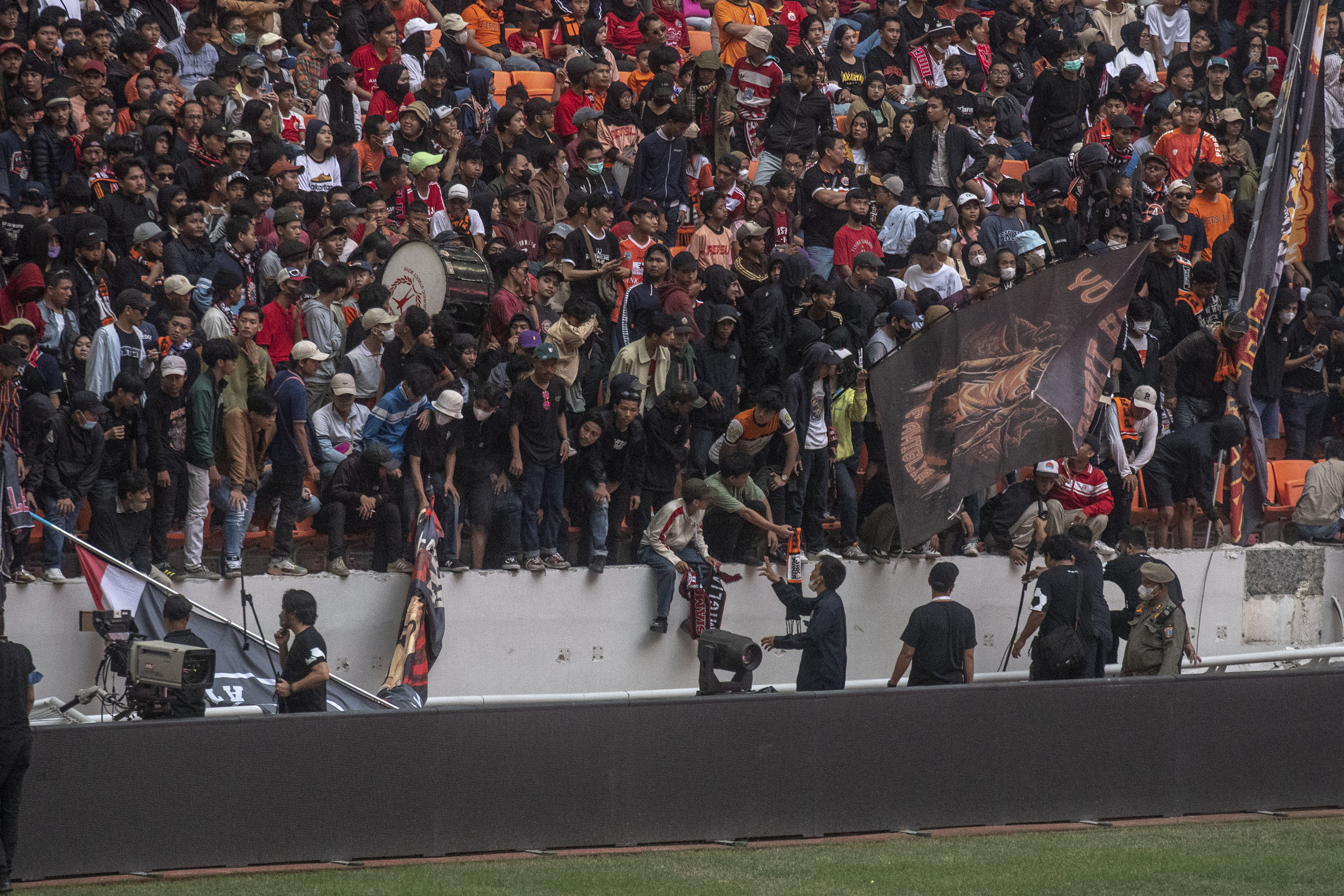 Sejumlah penonton berdiri di pagar pembatas yang roboh saat peresmian Stadion JIS, Jakarta.