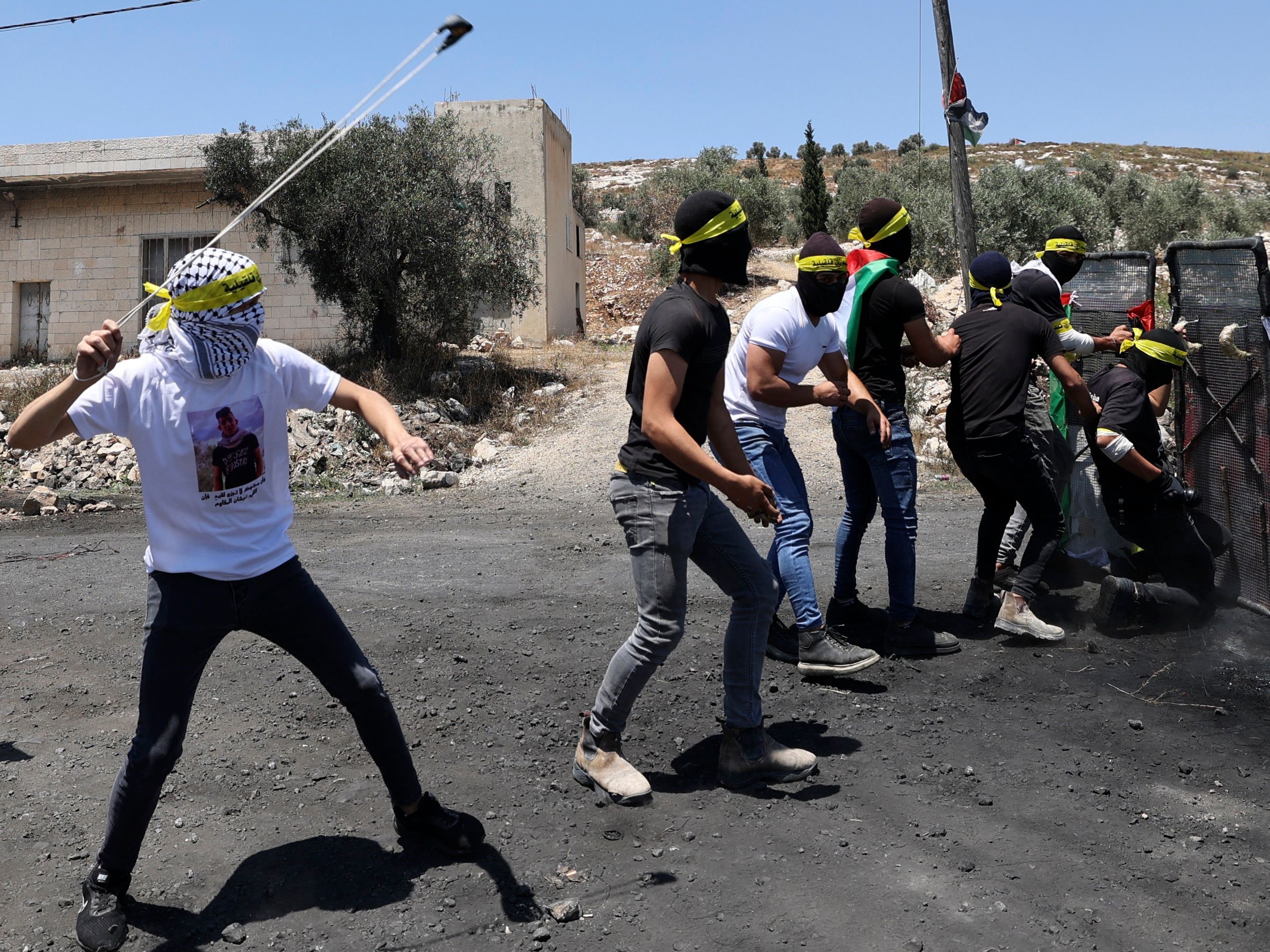 Pemuda Palestina menggunakan penghalang darurat selama bentrokan dengan pasukan Israel menyusul demonstrasi menentang pengambilalihan tanah.