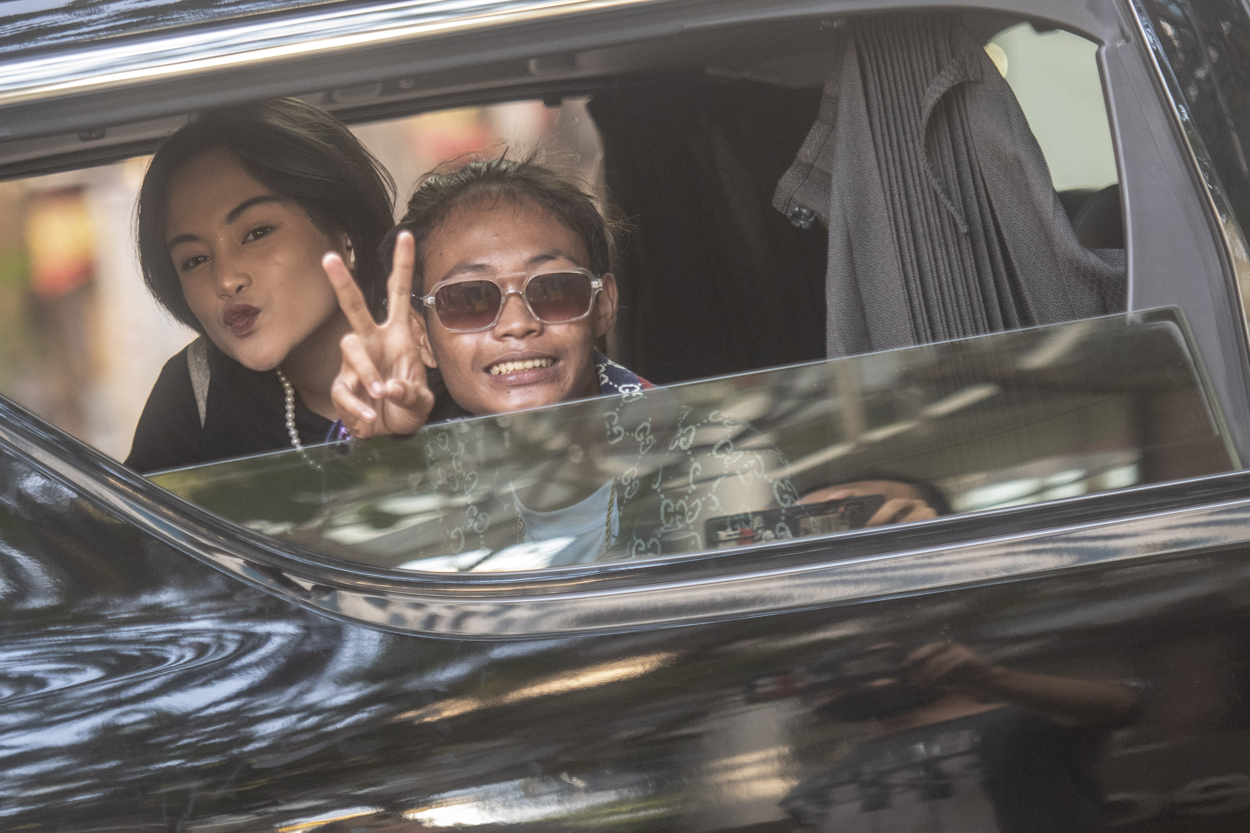 Pegiat TikTok Bonge (kanan) dan Jeje (kiri) menyapa dari atas mobil di kawasan Taman Stasiun MRT Dukuh Atas