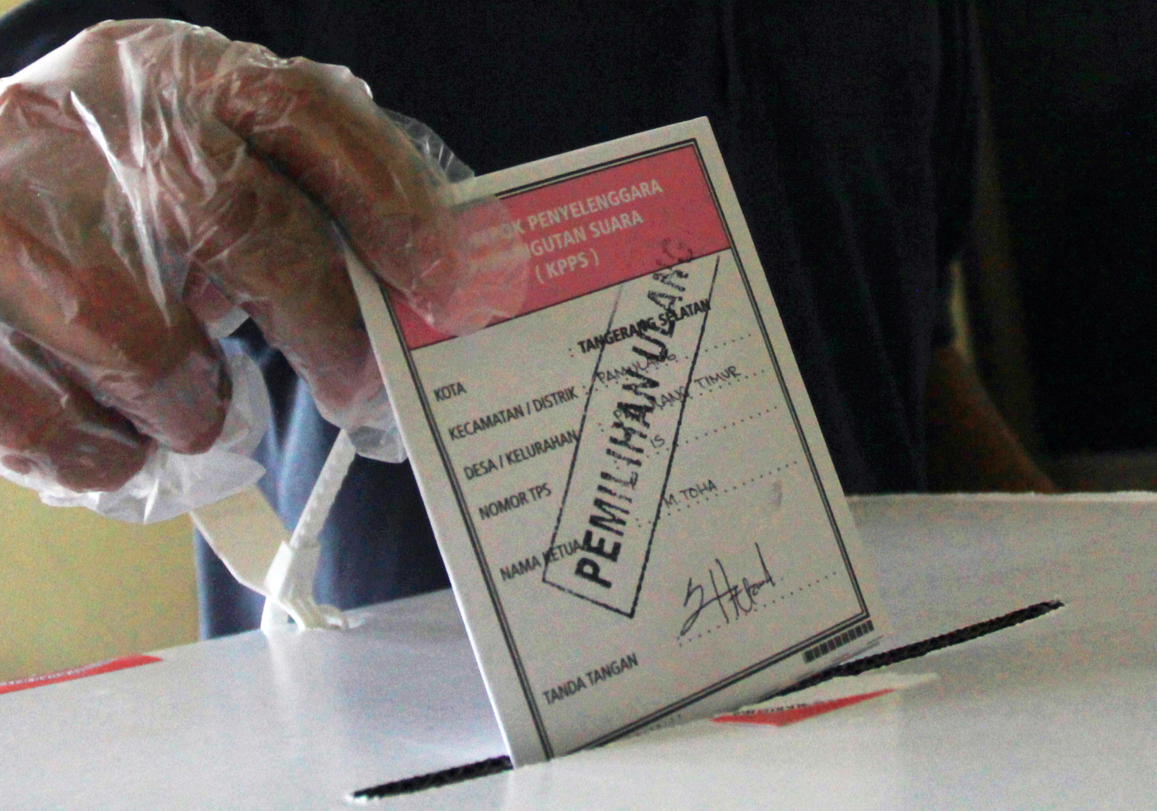 Ilustrasi seorang pemiliih memasukkan surat suara ke dalam kotak khusus di TPS.