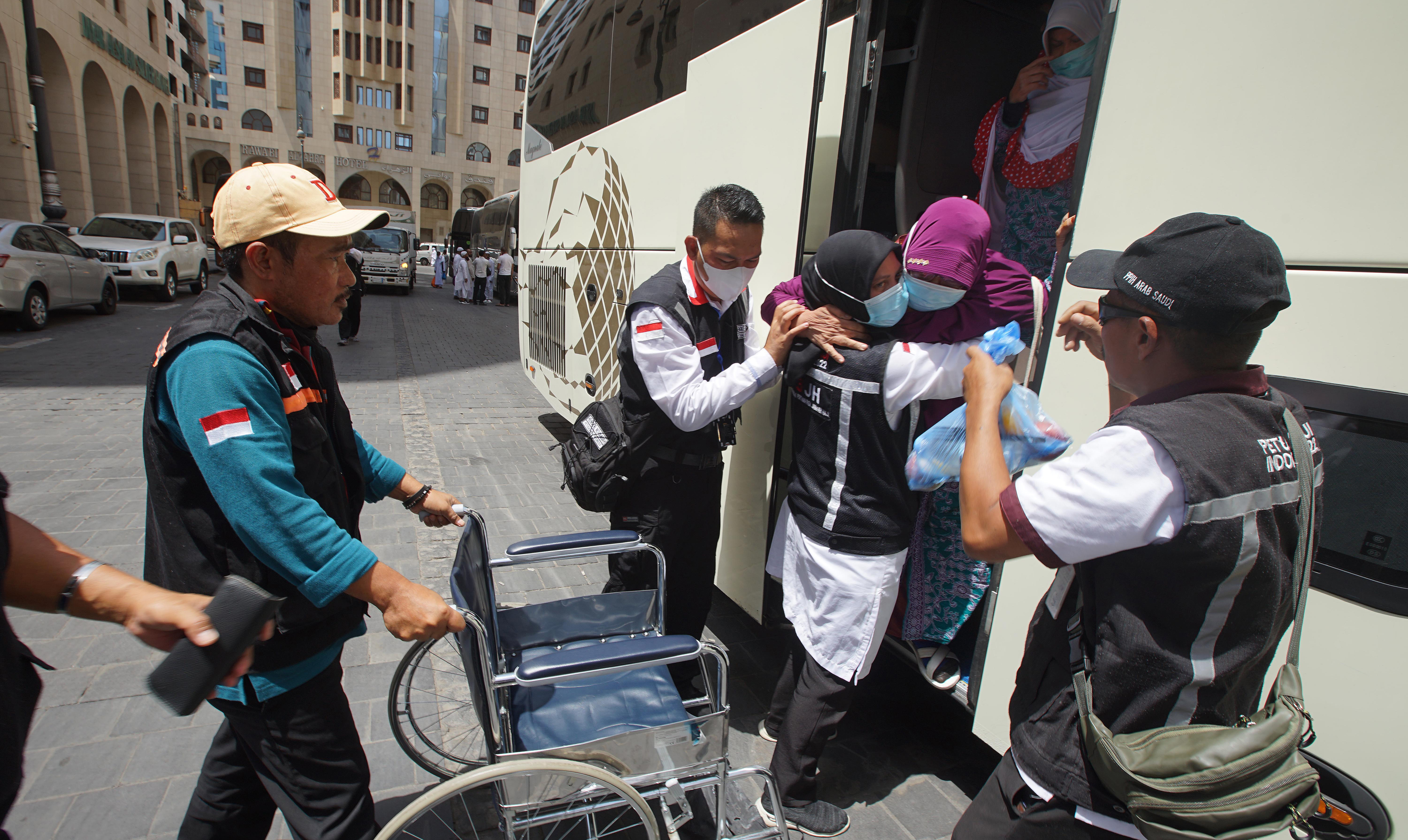 PEMULANGAN JEMAAH: Petugas PPIH membantu jemaah haji Indonesia dari Kloter Jakarta-Pondok Gede dari Mekkah tiba di  Madinah, Kamis (21/7)