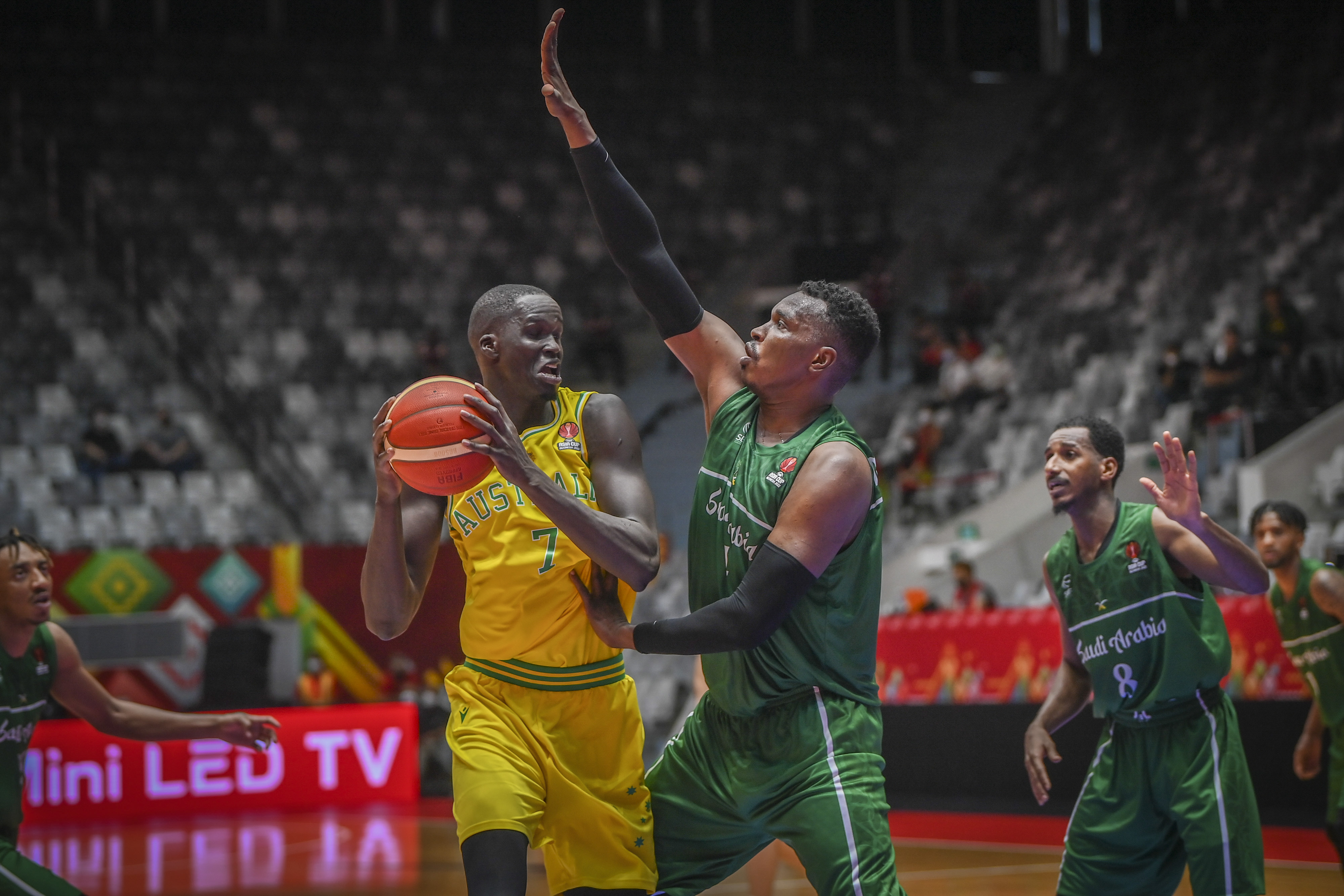 Pebasket Australia Thon Maker (kiri) berusaha melewati hadangan pemain Arab Saudi Mohammed Aimarwani (tengah).