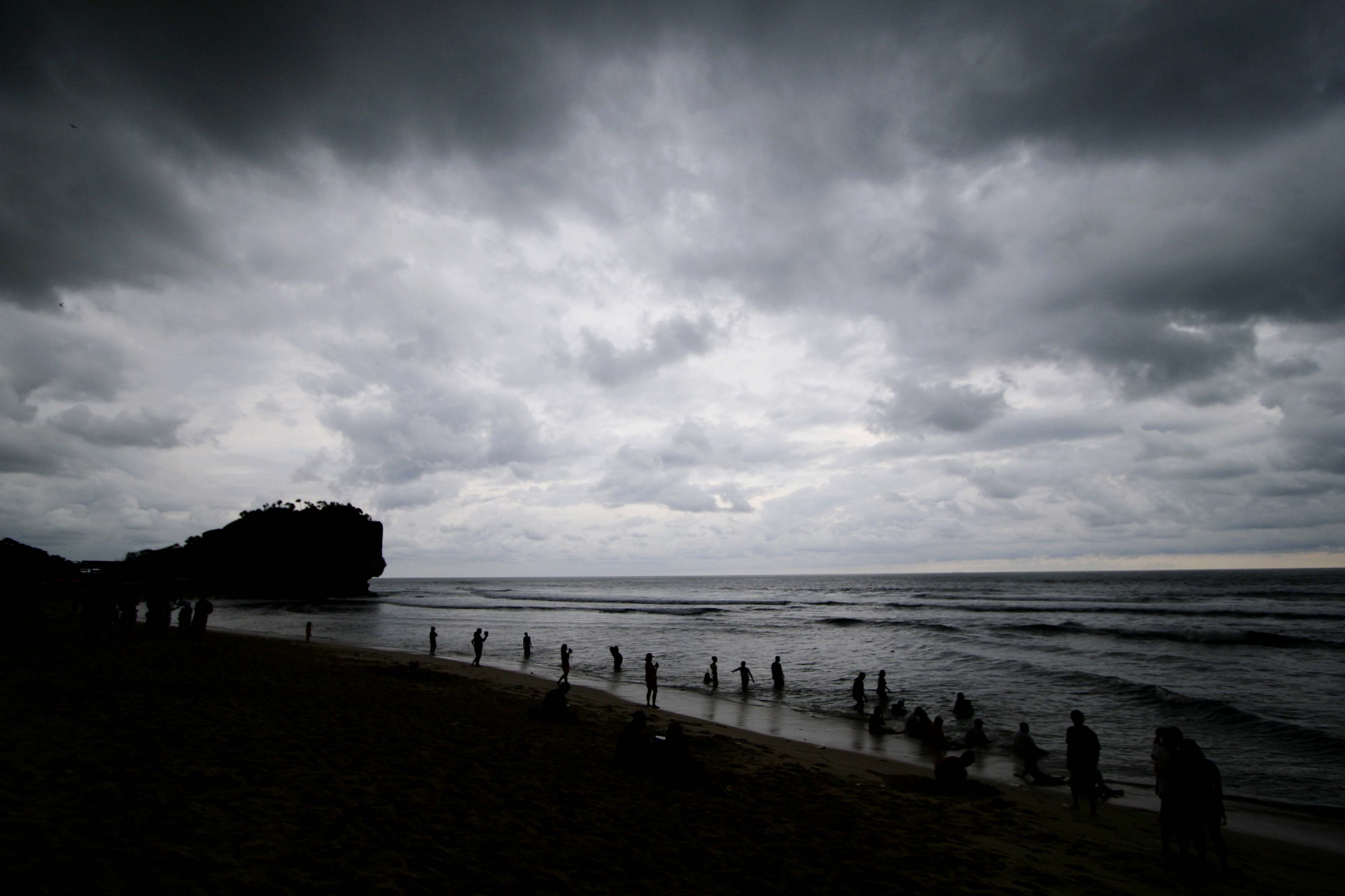 Pengunjung berwisata di pantai wilayah Gunung Kidul, Yogyakarta, di tengah cuaca mendung.