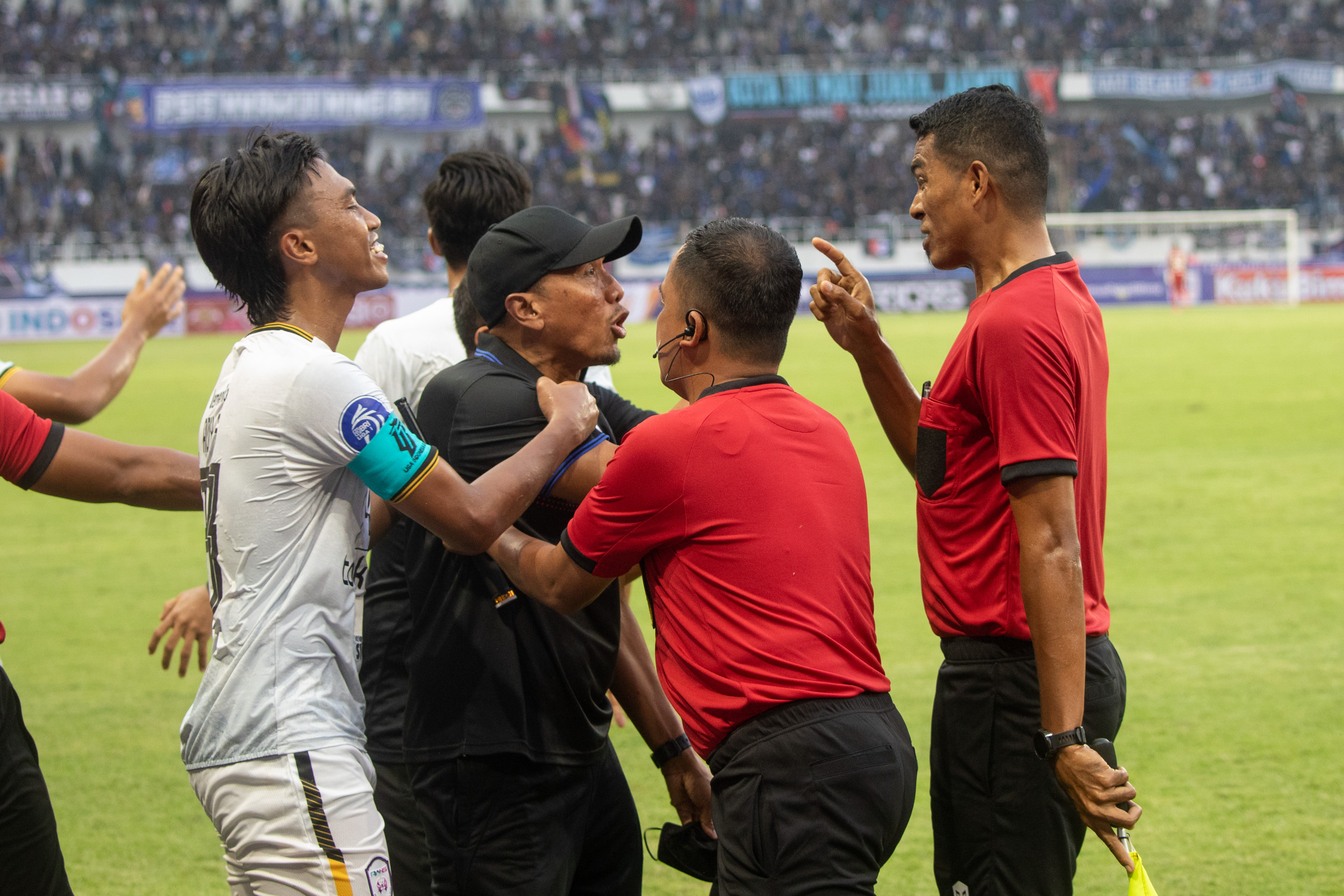 Pelatih Rans Nusantara FC Rahmad Darmawan (kedua kiri) memprotes keputusan wasit yang memberikan hukuman penalti kepada timnya.