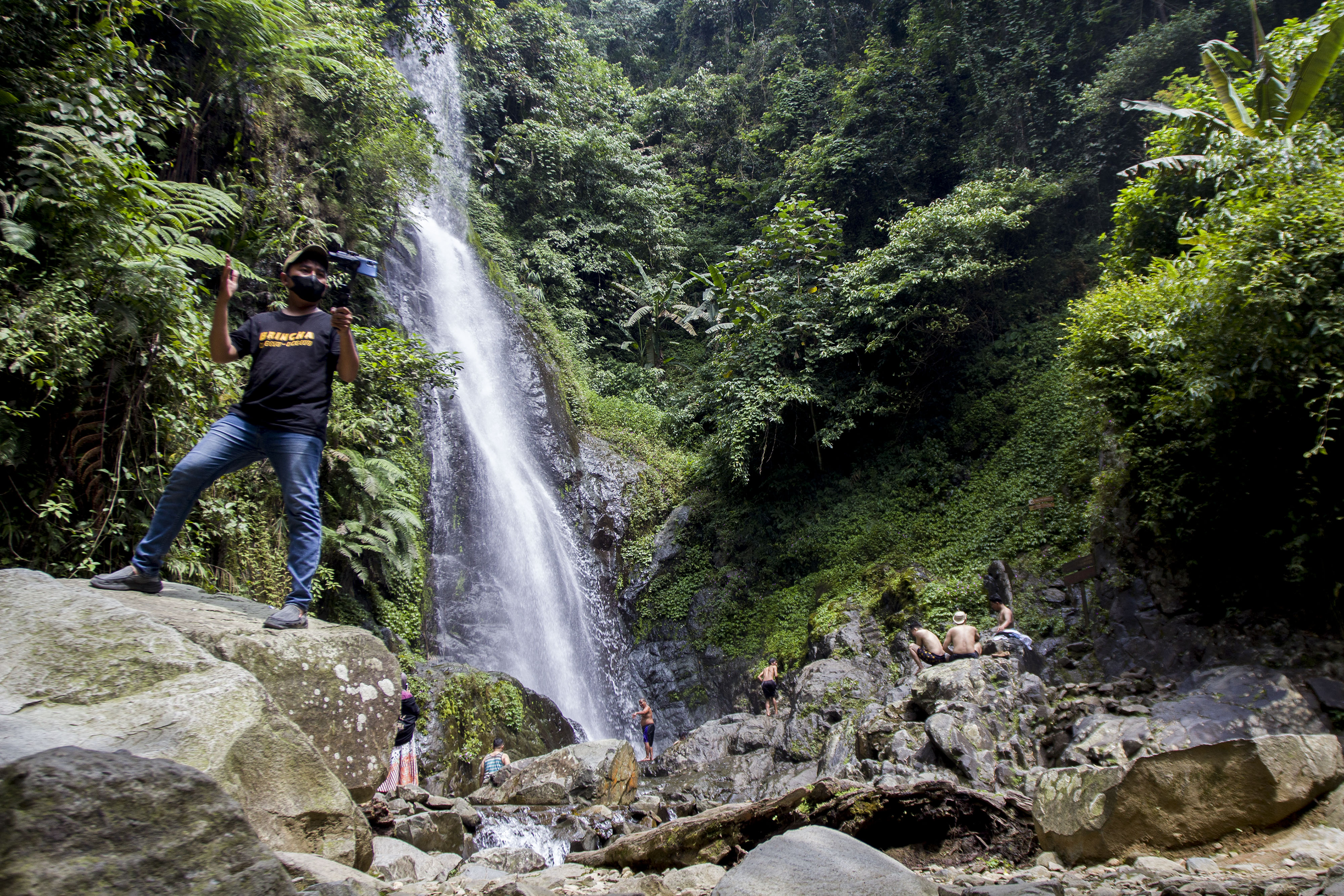Seorang vlogger sedang mengambil video di Curug Cigeuntis, Karawang, Jawa Barat