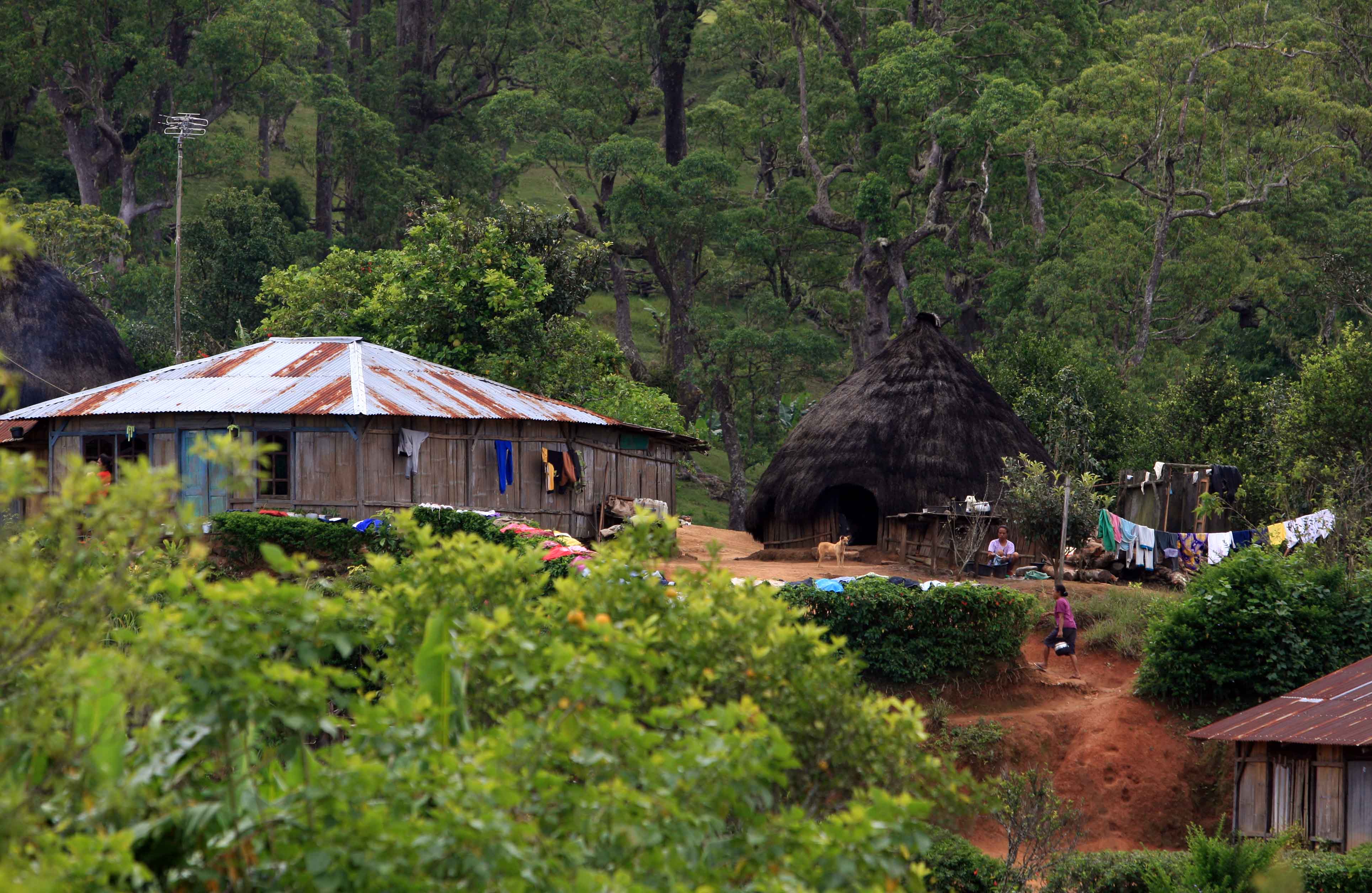 Warga beraktivitas di depan rumah adat di desa Fatumnasi, Timor Tengah Selatan, Nusa Tenggara Timur, Sabtu (7/5).