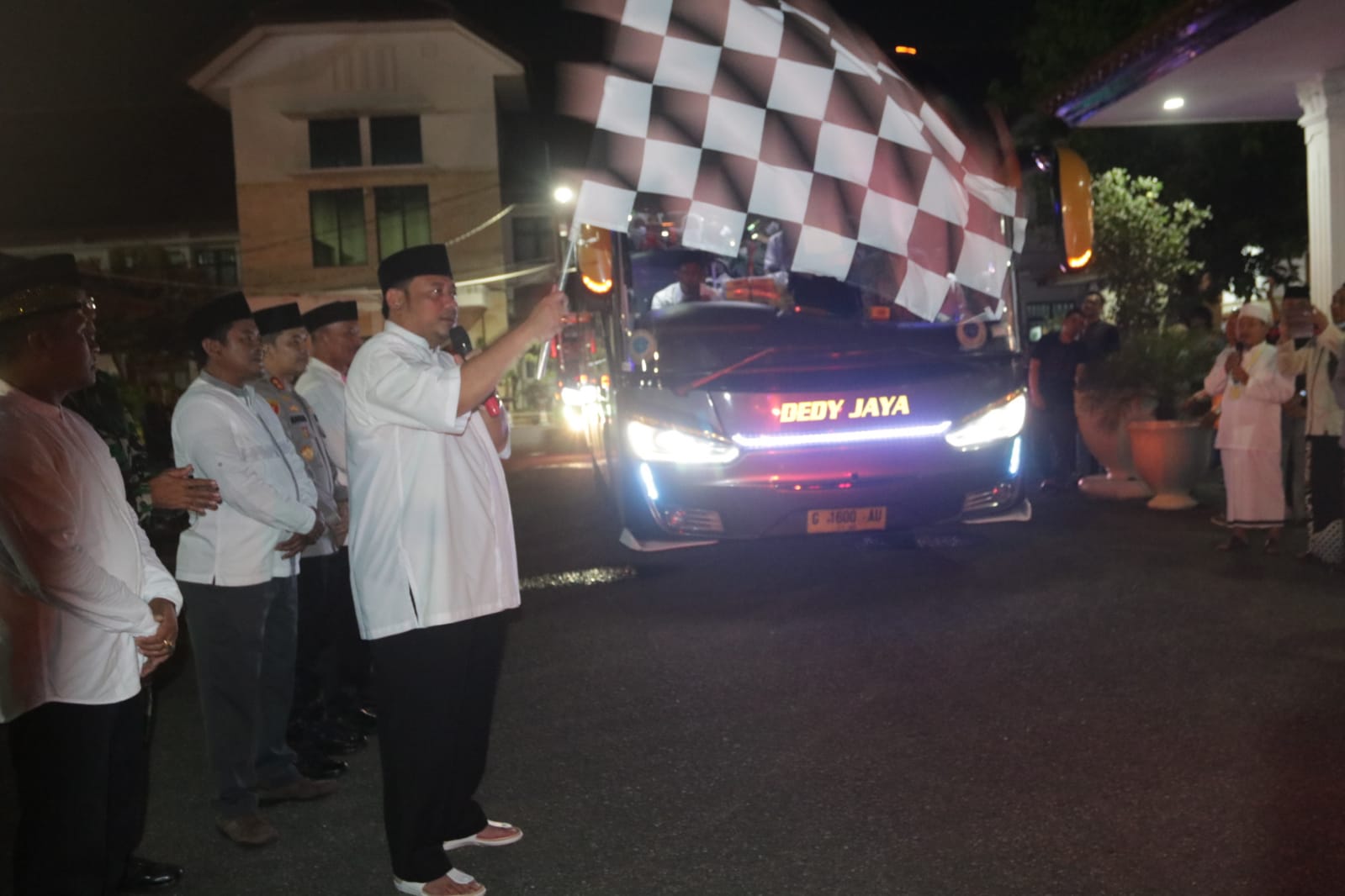 Walikota Tegal Dedy Yon Supriyono mengibarkan bendera tanda pemberangkatan jemaah calon haji.