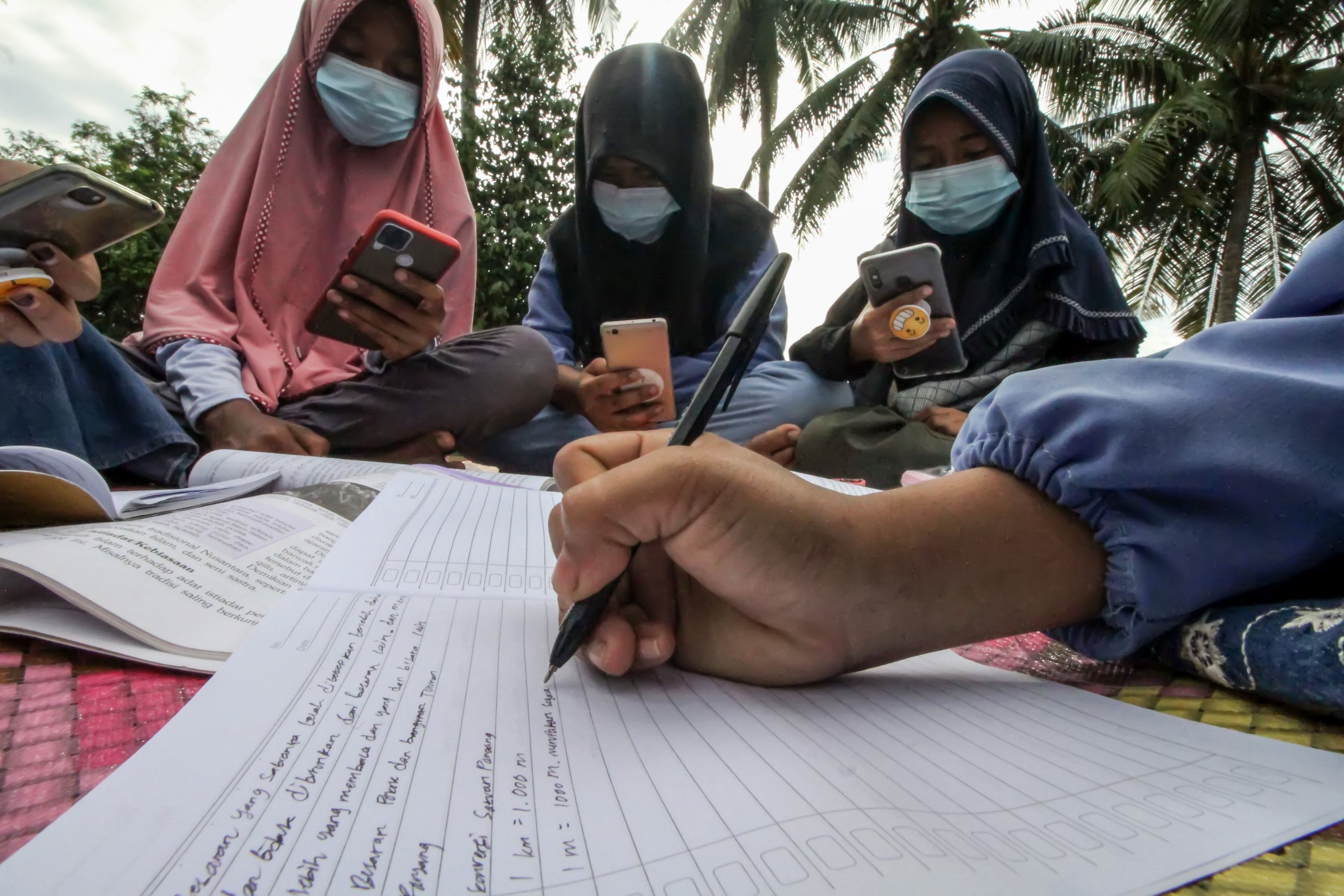 Sejumlah pelajar mengikuti proses belajar mengajar dalam jaringan (daring) di atas atap rumah warga di Desa Meuria Paloh, Aceh.