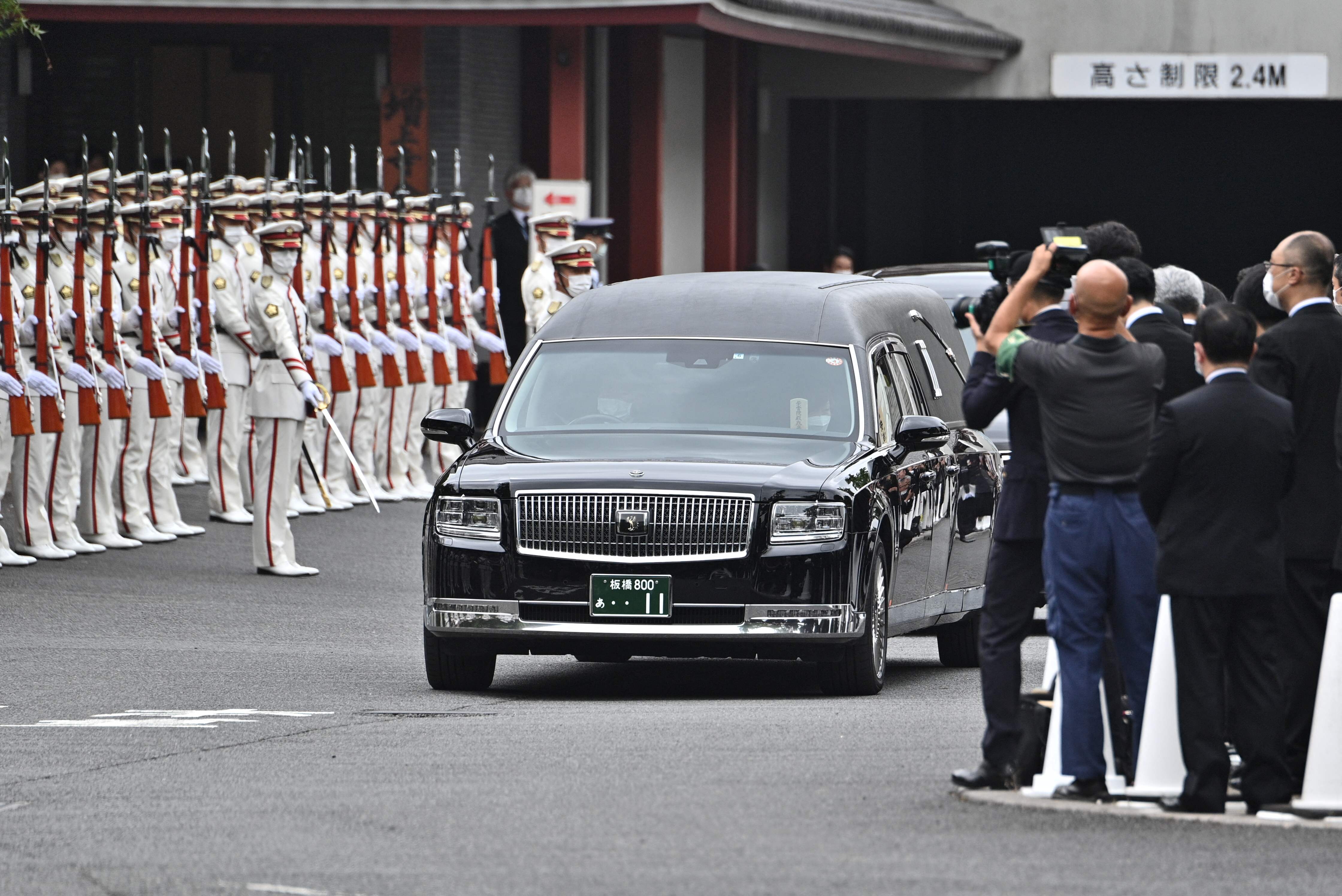 Mobil jenazah yang membawa mendiang mantan PM Jepang Shinzo Abe meninggalkan Kuil Zojoji di Tokyo, Jepang. Selasa (12/7).