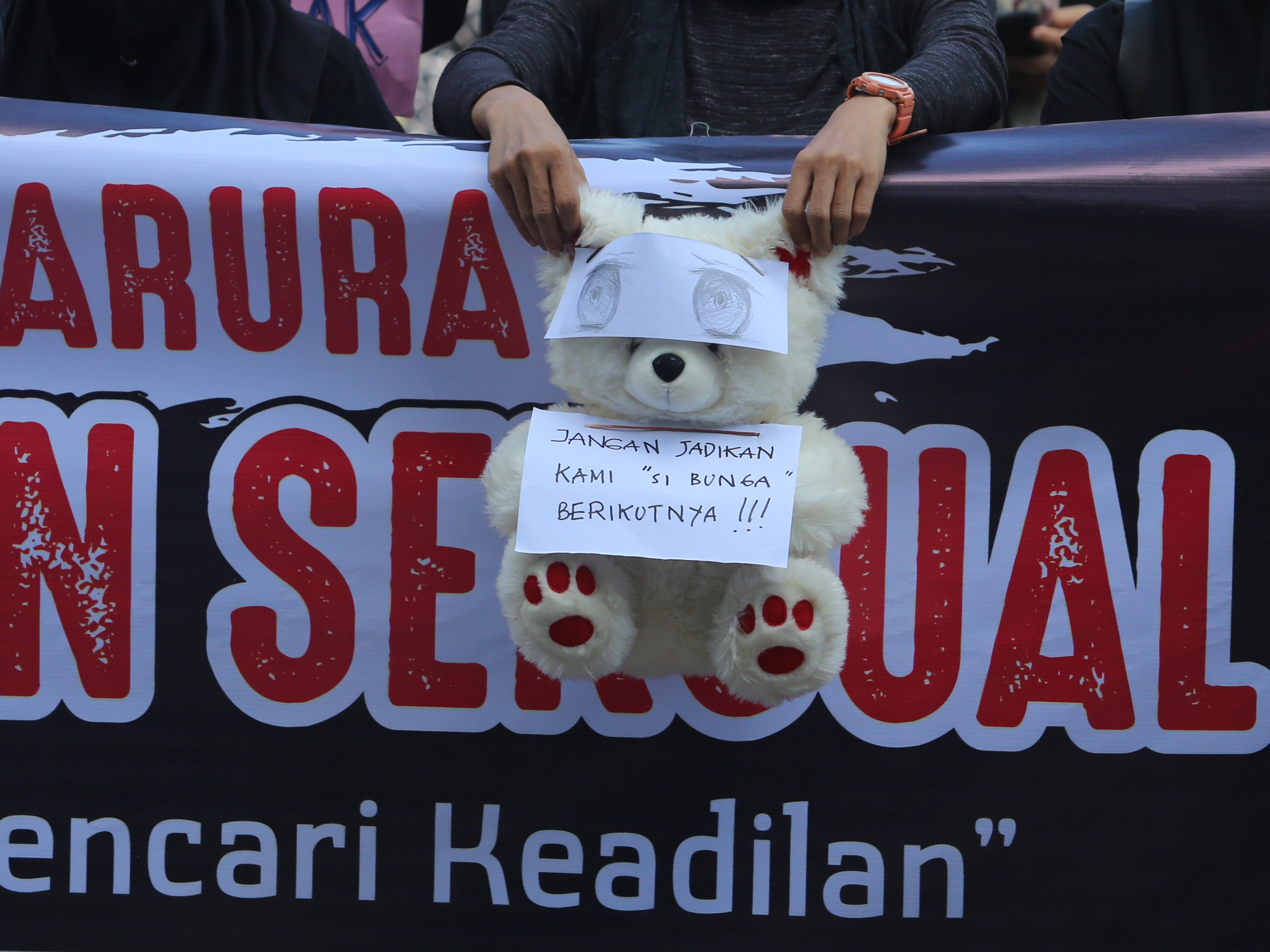 Peserta aksi memegang boneka bertuliskan, 