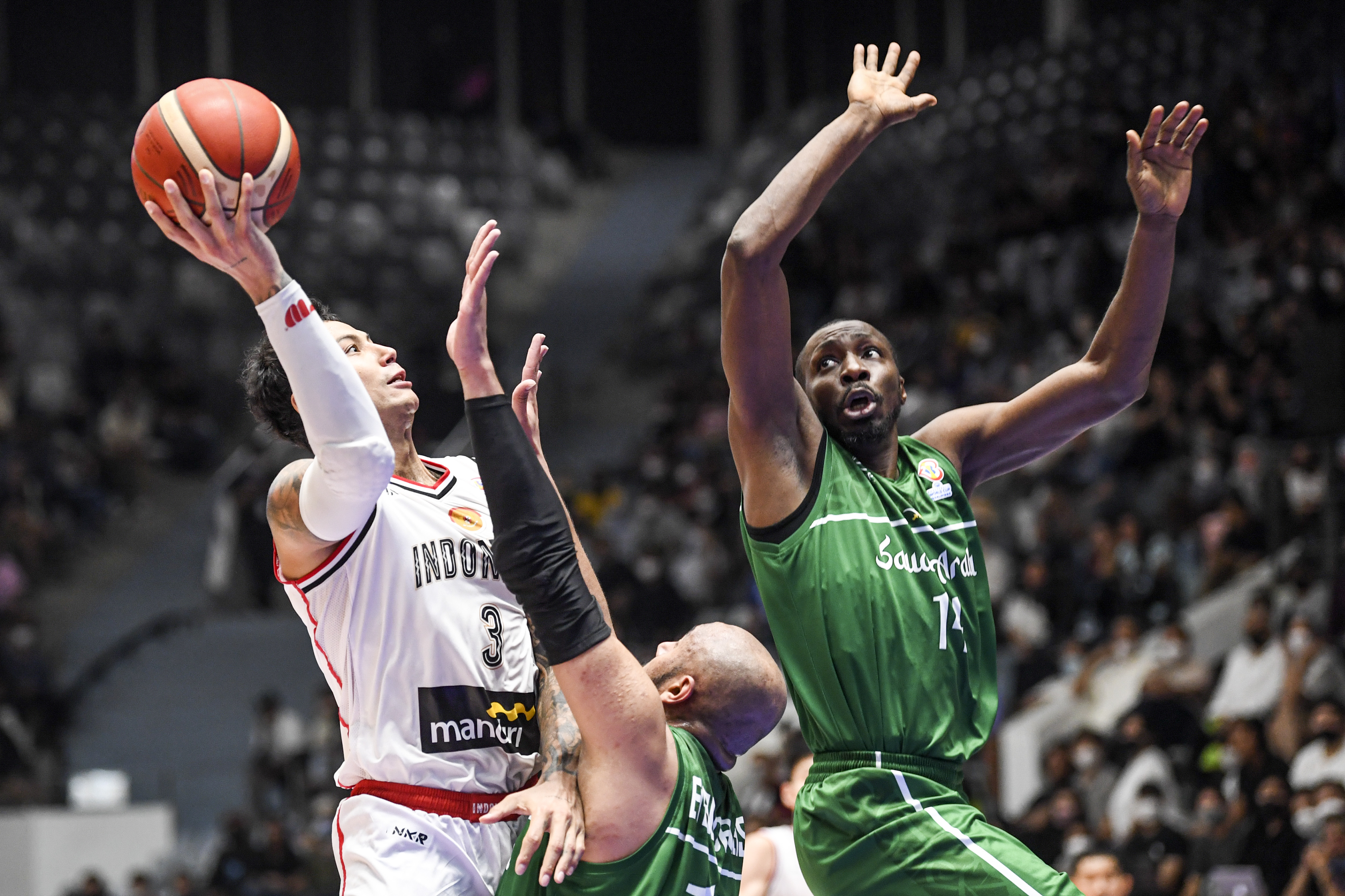  Pebasket Timnas Indonesia Brandon Jawato (kiri) melewati hadangan pebasket Timnas Arab Saudi Nassir Abo Jallas (tengah).